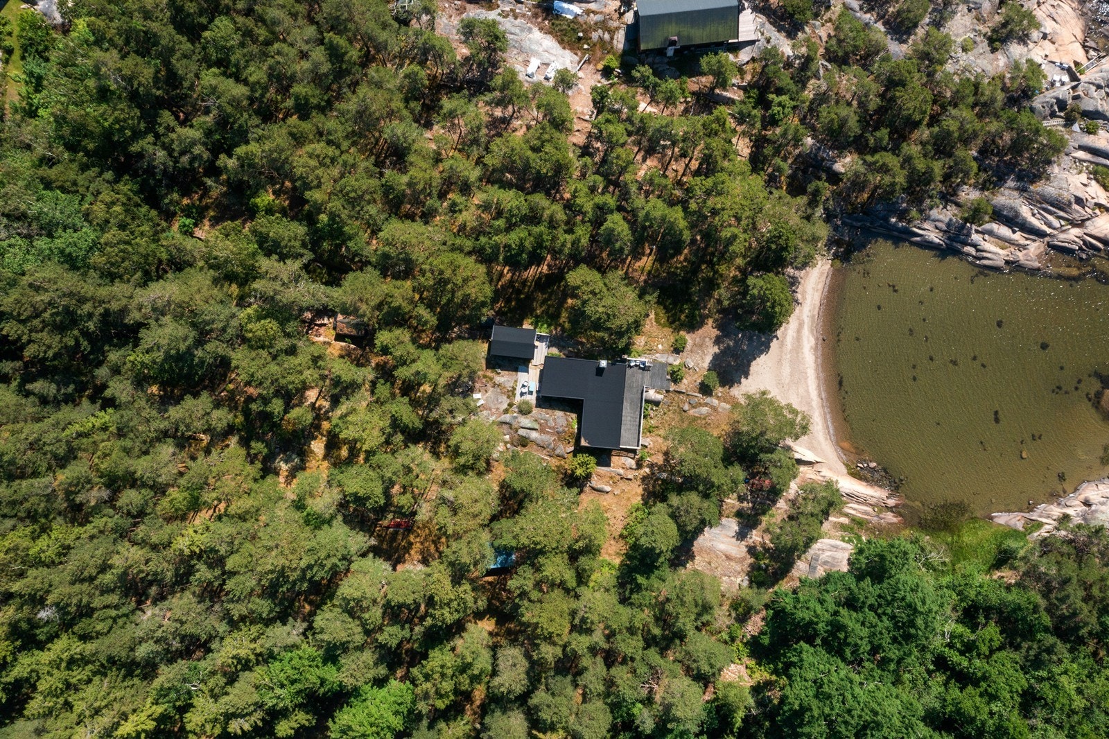 Oversiktsbilde som viser hyttas plassering i terrenget, tett på naturen. Galleribilde