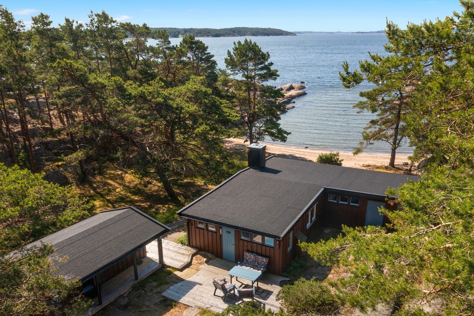 Baksiden av hytta med uteplasser og inngangsparti. Galleribilde