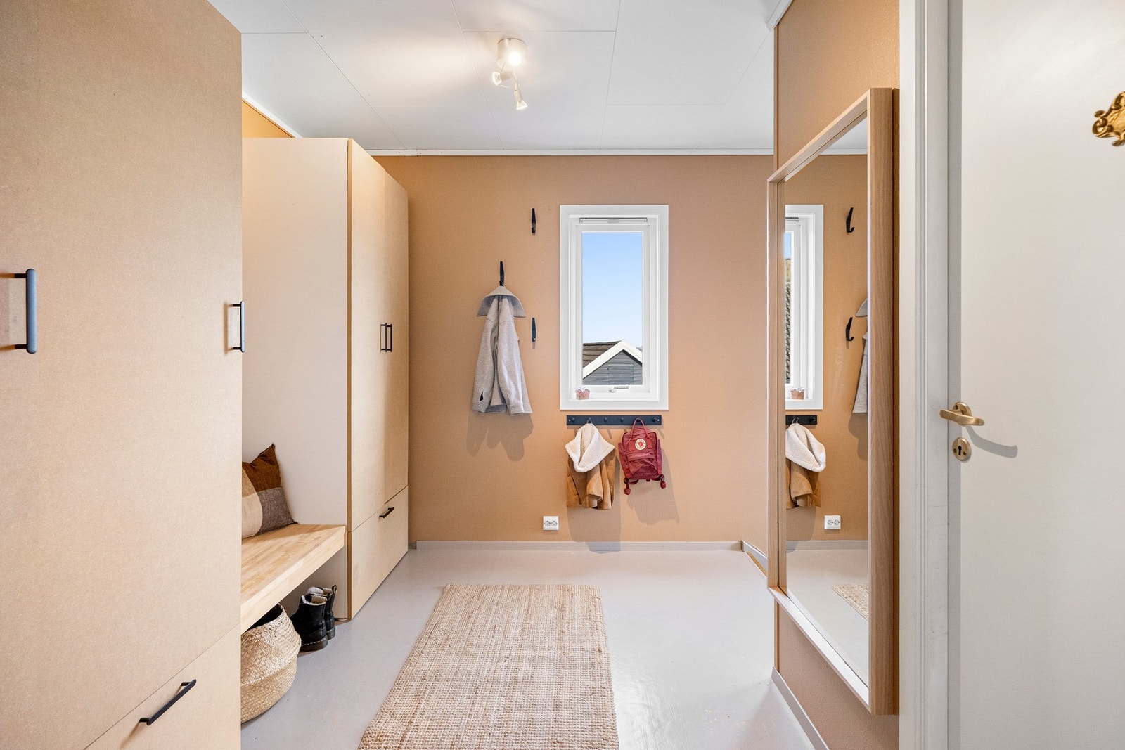 En stor og romslig entré med rikelig skapplass, som gir en praktisk og ryddig velkomst til boligen. Galleribilde