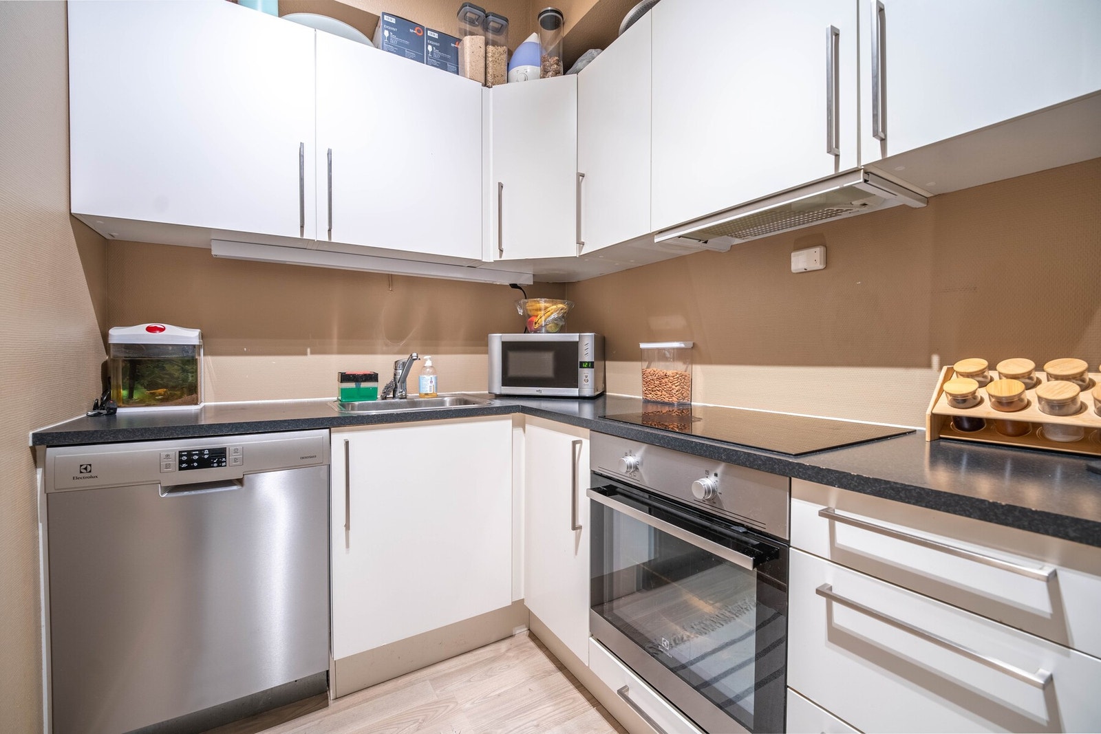 Innredningen har integrerte hvitevarer, herunder stekeovn med nedfelt platetopp, komfyrvakt og ventilator i overskap samt frittstående kjølekap og oppvaskmaskin Galleribilde