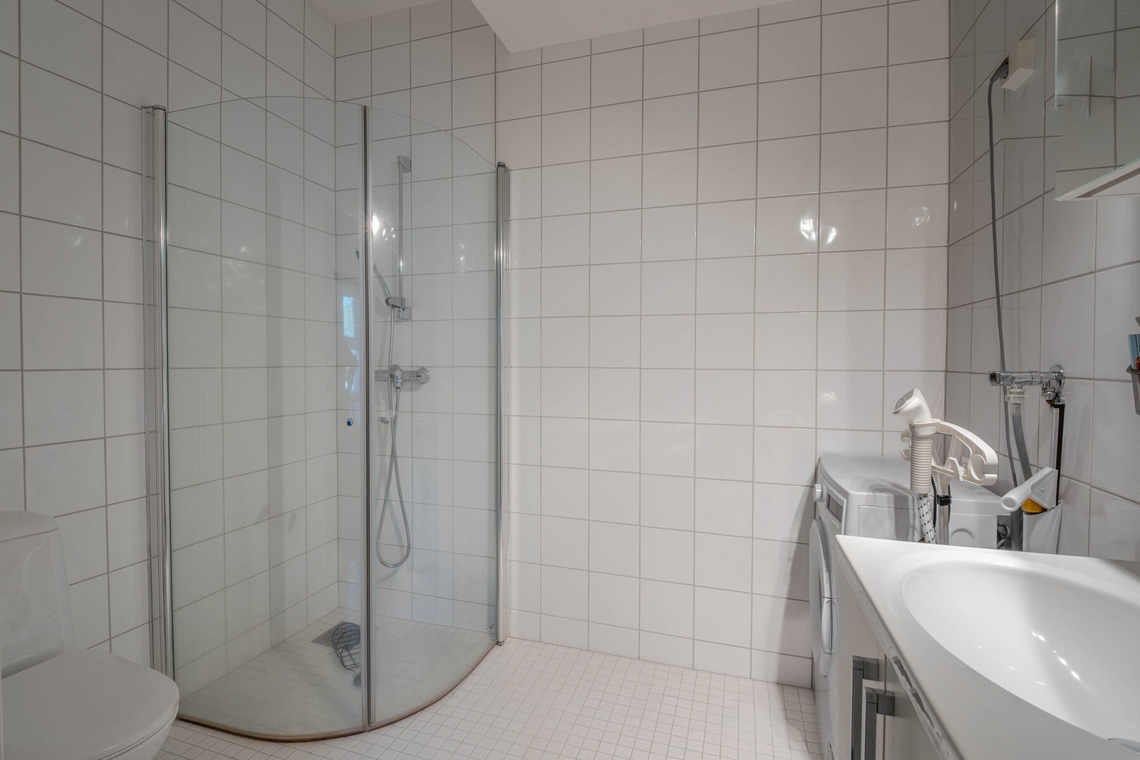 Badet er innredet med dusjhjørne med innfellbare vegger og gulvstående toalett Galleribilde