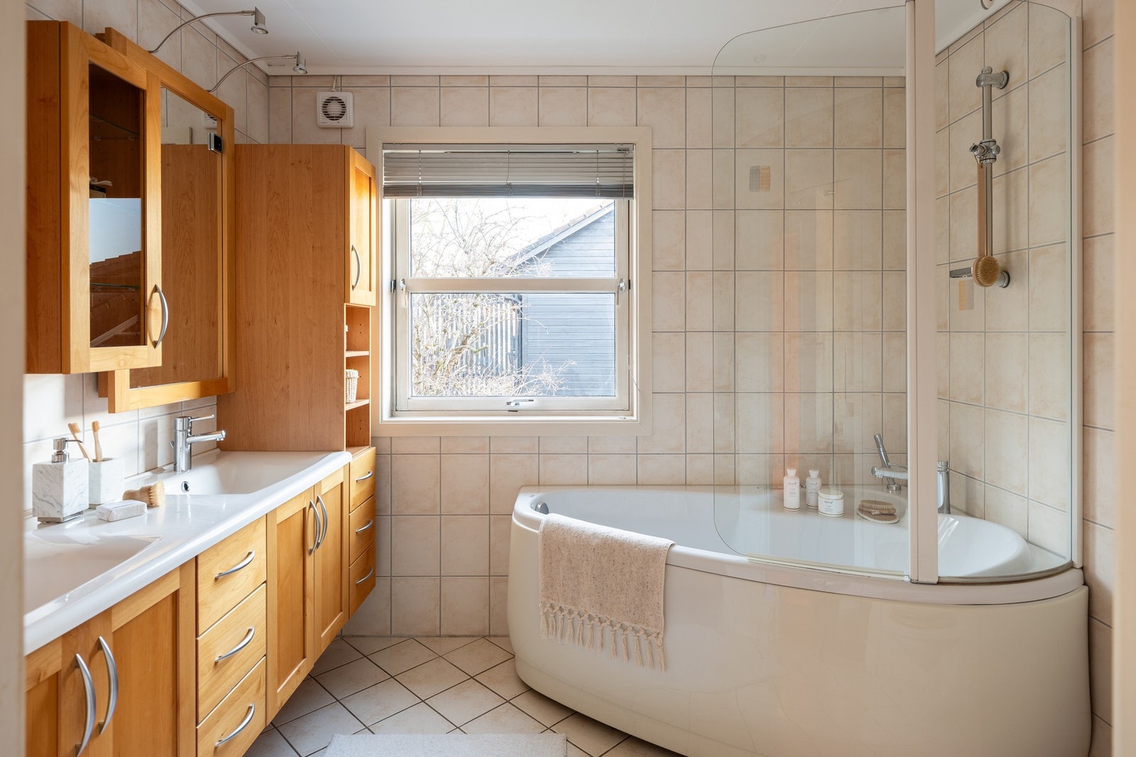 Flislagt bad med varme i gulv. Badet har stor innredning med servant, badekar og toalett. Galleribilde