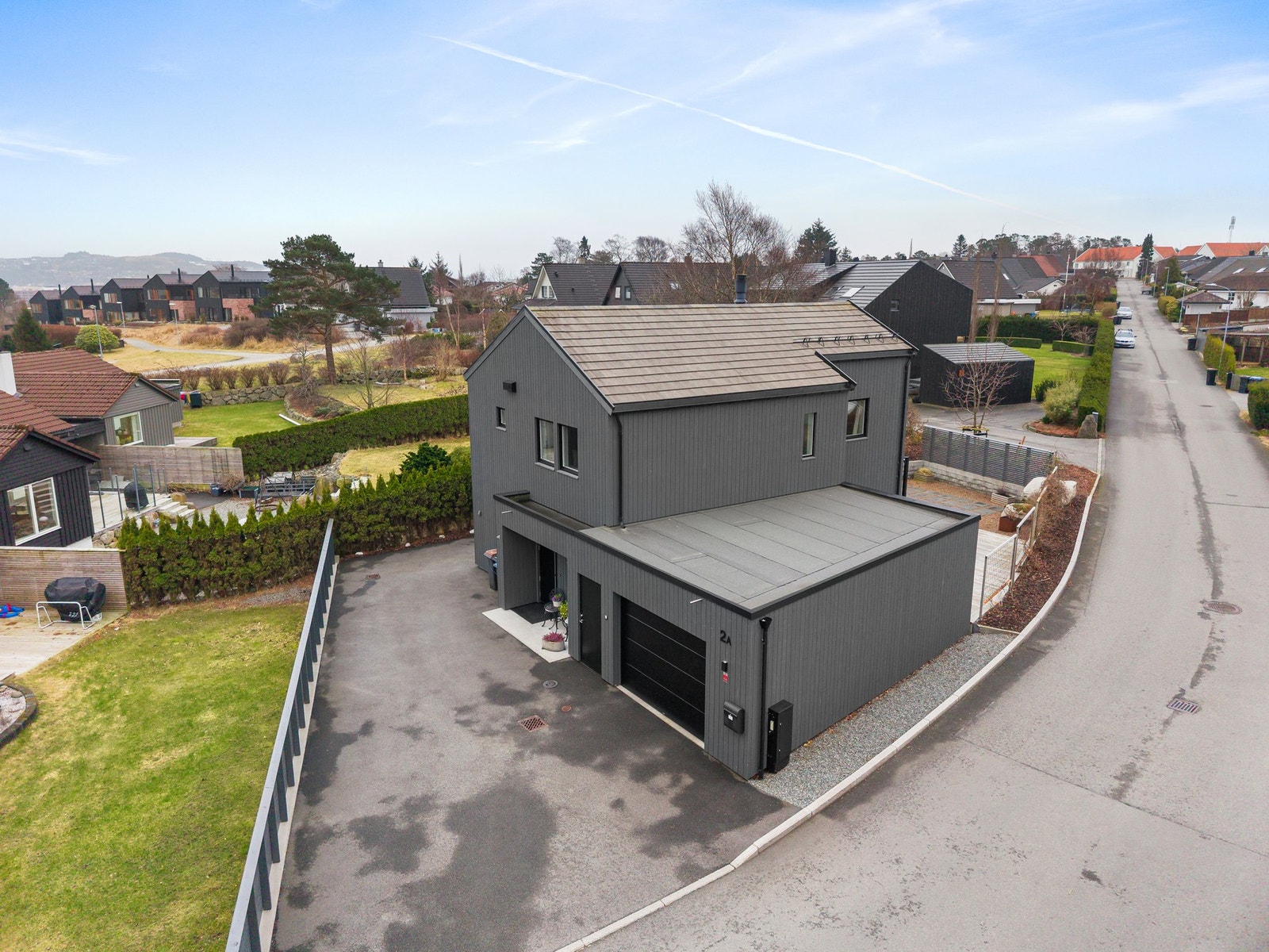 Parkering kan gjøres på asfaltert gårdsrom og i stor garasje, her er det montert elbil lader av type Easee. Galleribilde