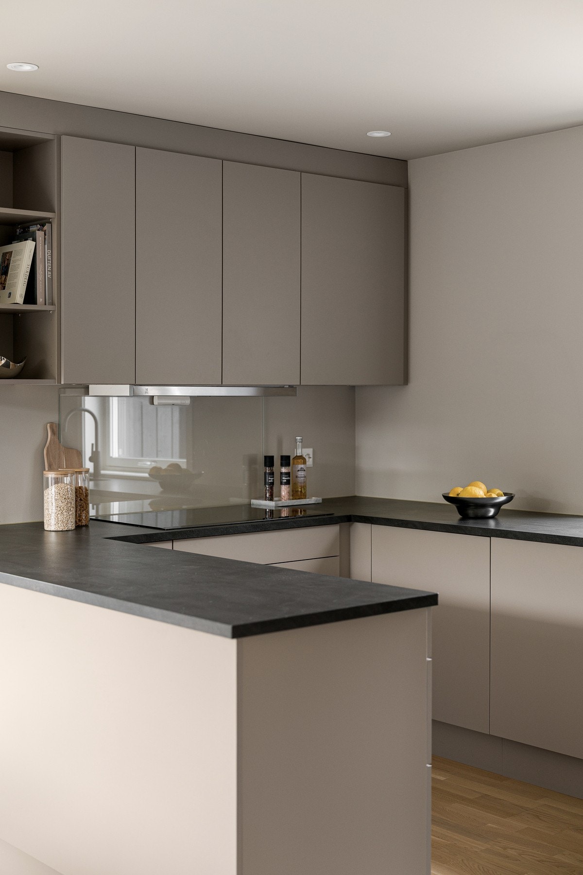 Innredningen har slette fronter i fargen varmgrå, som harmonerer flott med den mørke laminatbenkeplaten og gir et tidsriktig og elegant uttrykk. Galleribilde