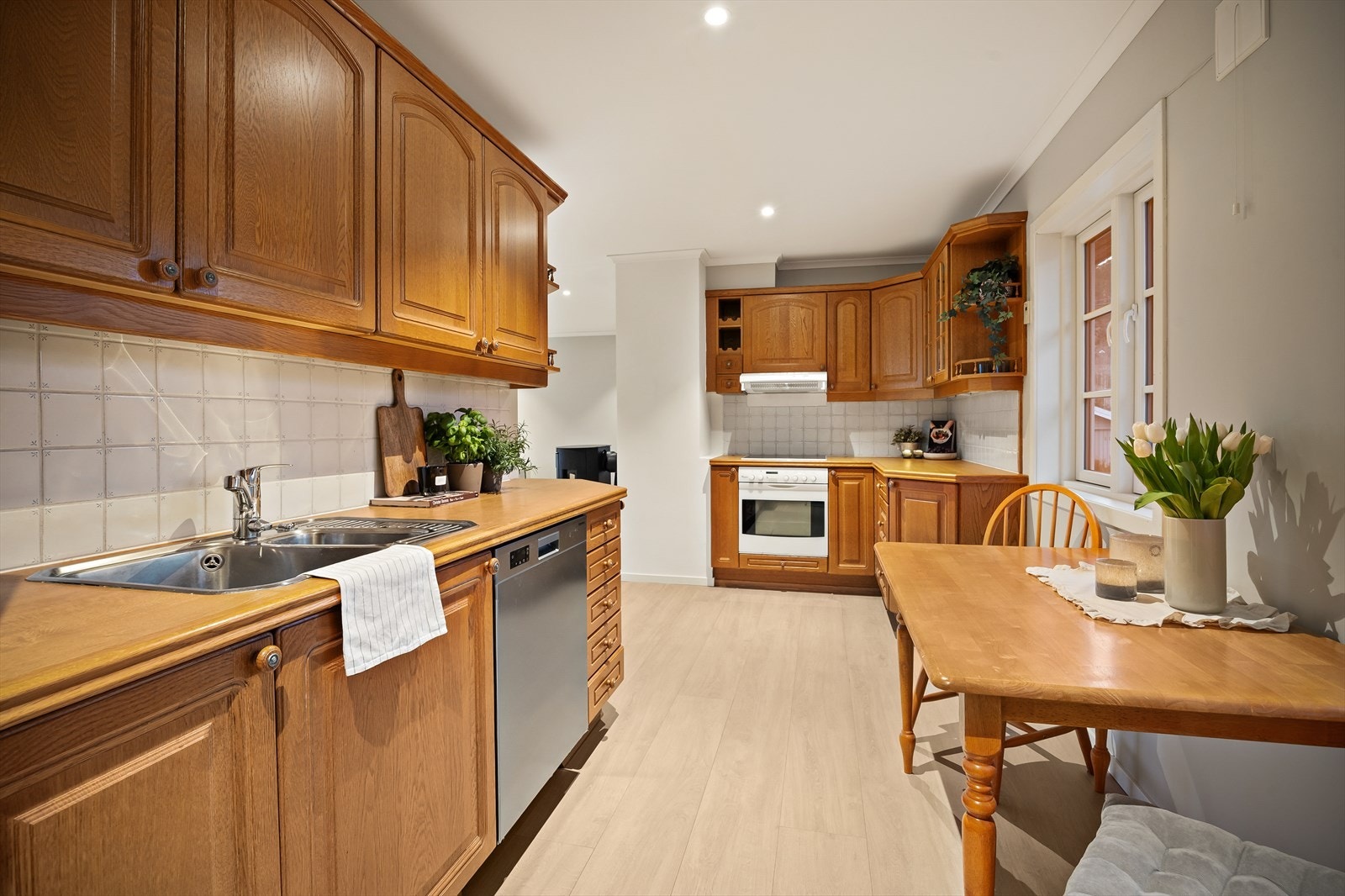 Kjøkkeninnredningen har profilerte fronter, laminat benkeplate og integrert stekeovn og platetopp. Galleribilde