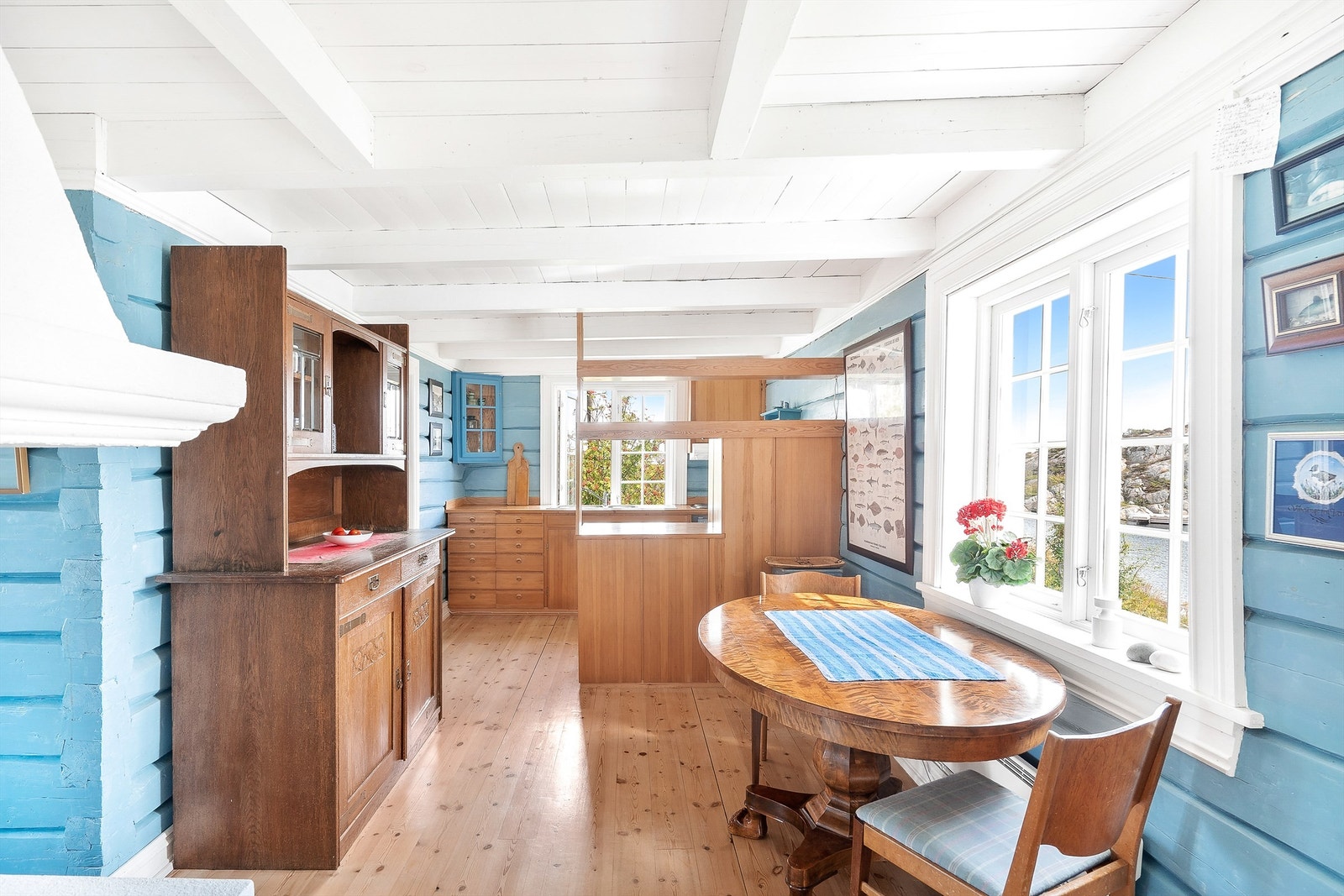 Også fra kjøkkenet er det svært hyggelig utsikt ut til hagen samt mot annekset og sjøen. Kjøkkenet har bevart de laftede veggene. Galleribilde