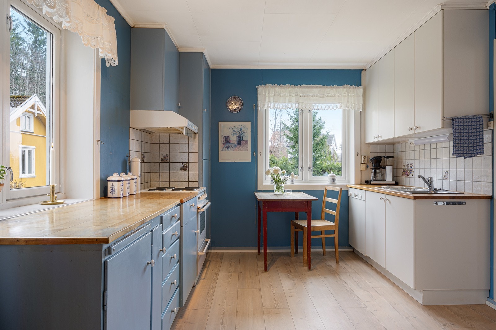 Innredningen har glatte fronter i hvitt og blått, og heltre benkeplate med dobbel oppvaskkum. Galleribilde