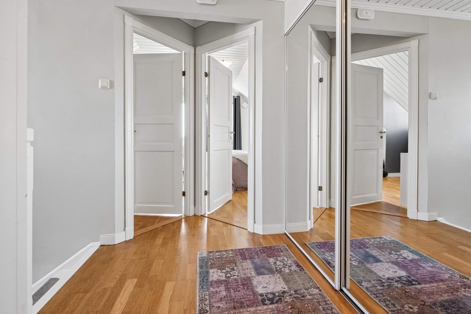 Gangen i andre etasje har parkett på gulvet og fordeler tilgangen til etasjens rom. Speil garderobe med praktisk lagringsplass Galleribilde
