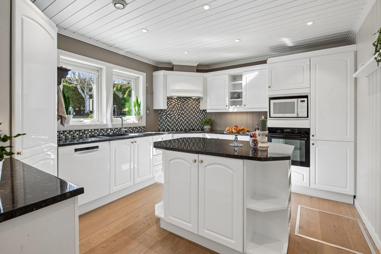 Kjøkkenet har en funksjonell innredning med profilerte fronter og en praktisk kjøkkenøy som gir ekstra arbeids- og lagringsplass. Galleribilde