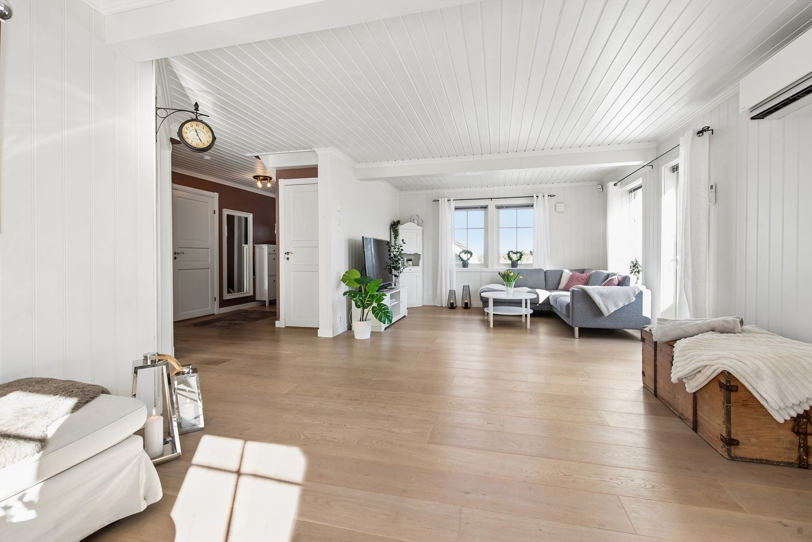 Gjennomgående laminatgulv og lyst, profilert trepanel i himlingen binder rommene i første etasje sammen. Galleribilde