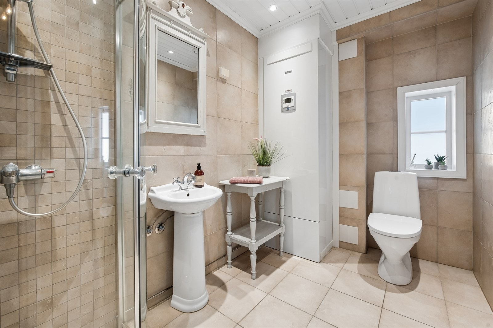 Badet i første etasje er helfliset og har gulvvarme, toalett og et dusjhjørne med glassvegger. Galleribilde