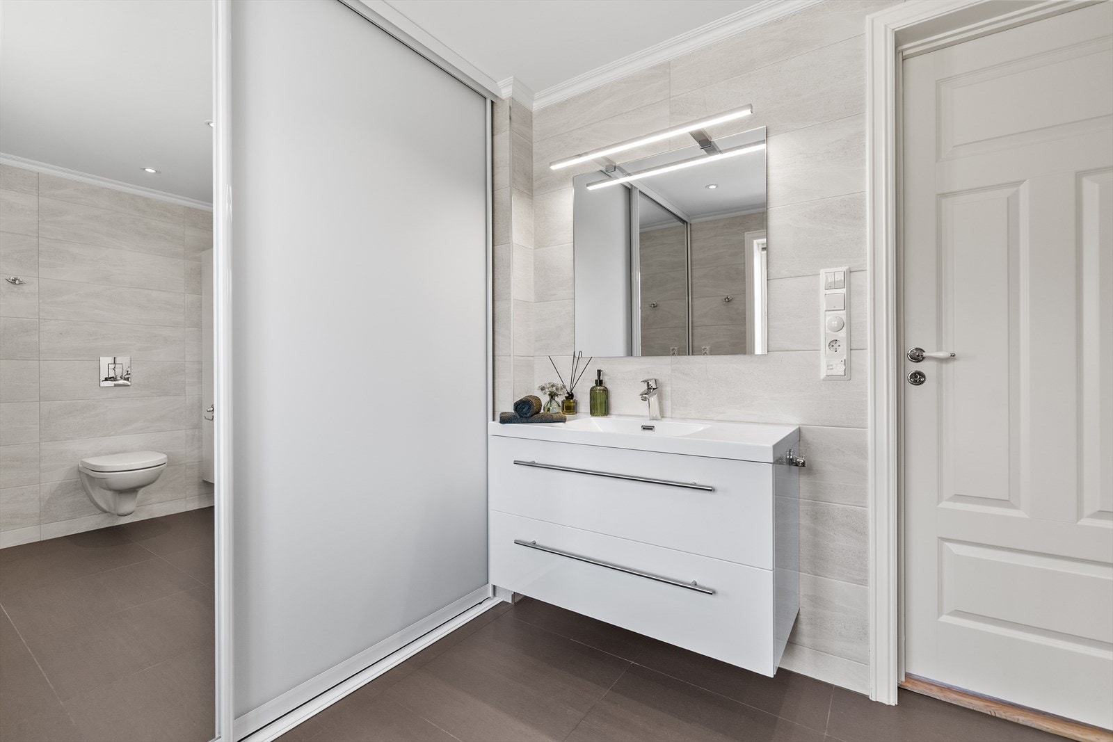 I skyvedørsgarderobe er det praktisk opplegg for vaskemaskin, varmtvannsbereder og sluk. Galleribilde