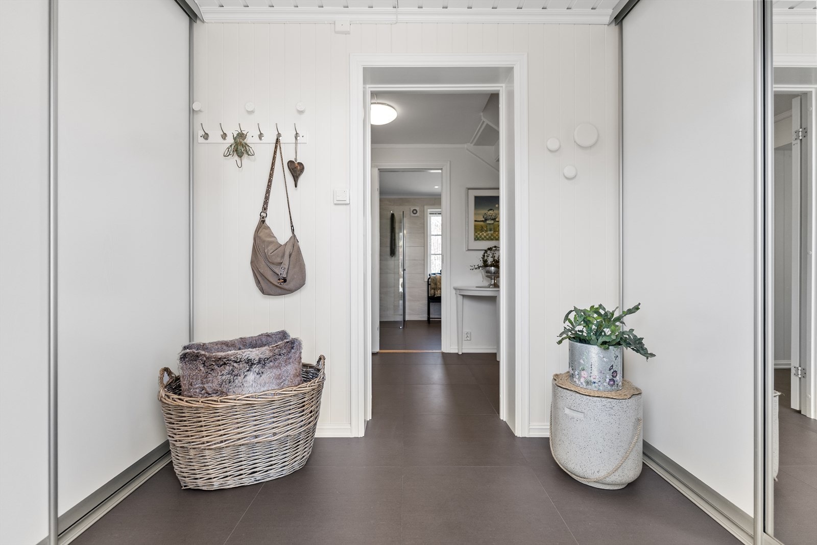 Entreen er romslig med god plass til oppbevaring i skyvedørsgarderobe. Gulvet er flislagt Galleribilde