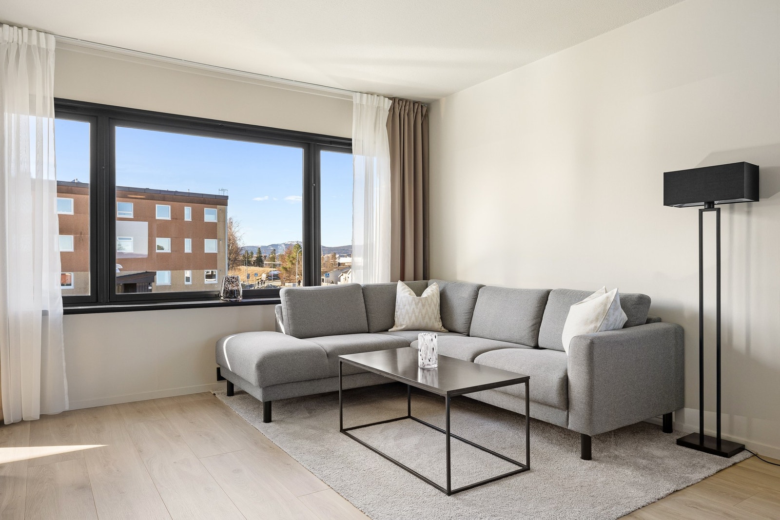 En gjenganger i leiligheten er boligens store vindusflater som slipper inn rikelig med naturlig lys og bidrar til en lett og luftig atmosfære. Galleribilde