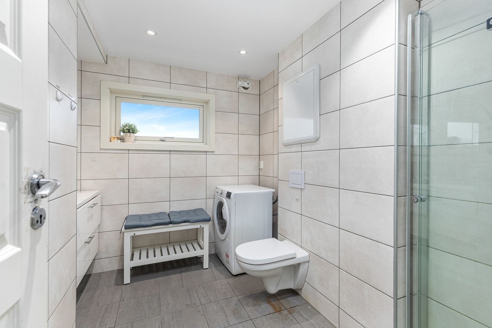 Lyst, flislagt bad med varme i gulvet og downlights i himling. Galleribilde