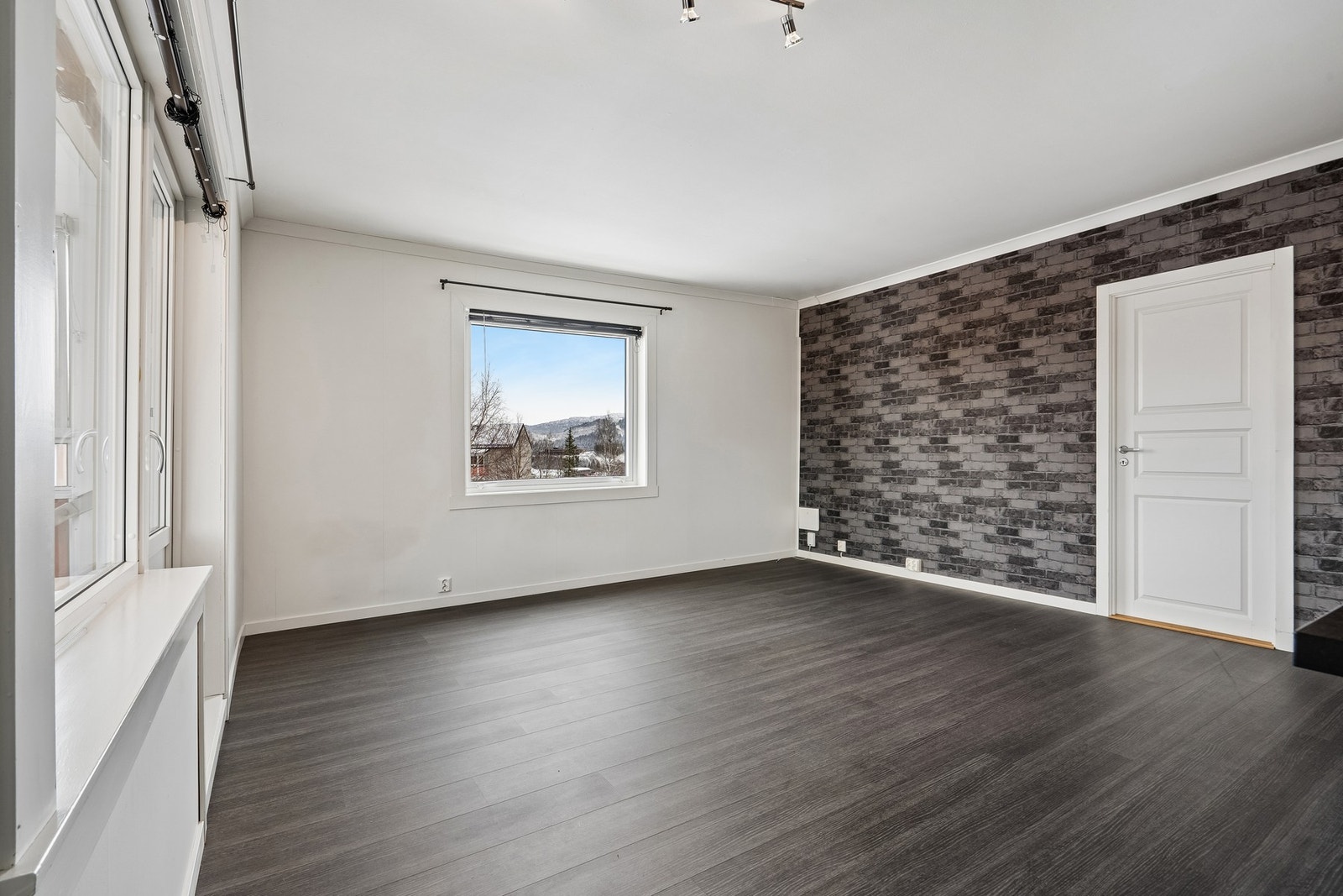 Stuen har flere store vindusflater som slipper inn godt med naturlig lys Galleribilde