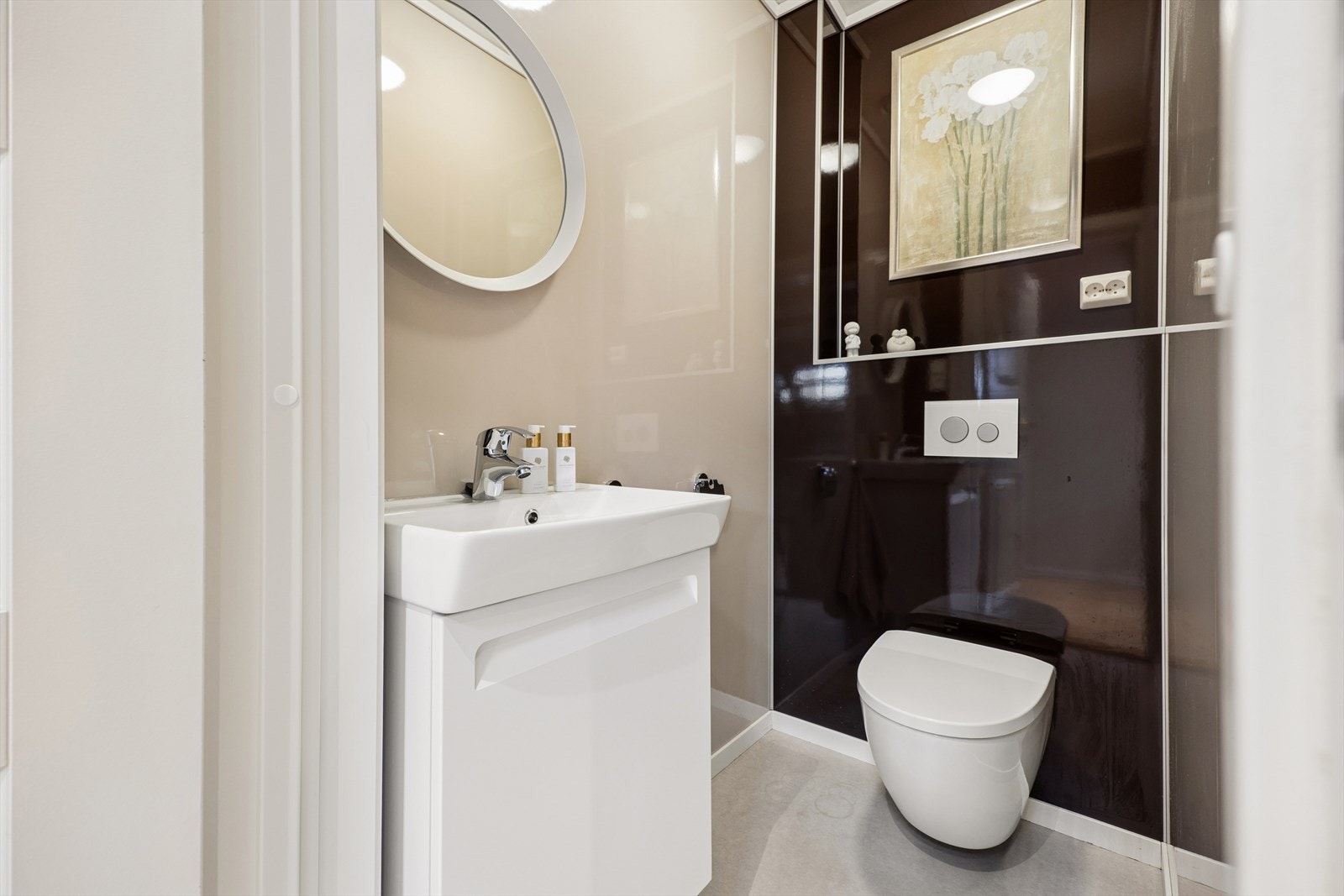 Toalettrommet er innredet med et vegghengt toalett og en vegghengt servant. Galleribilde