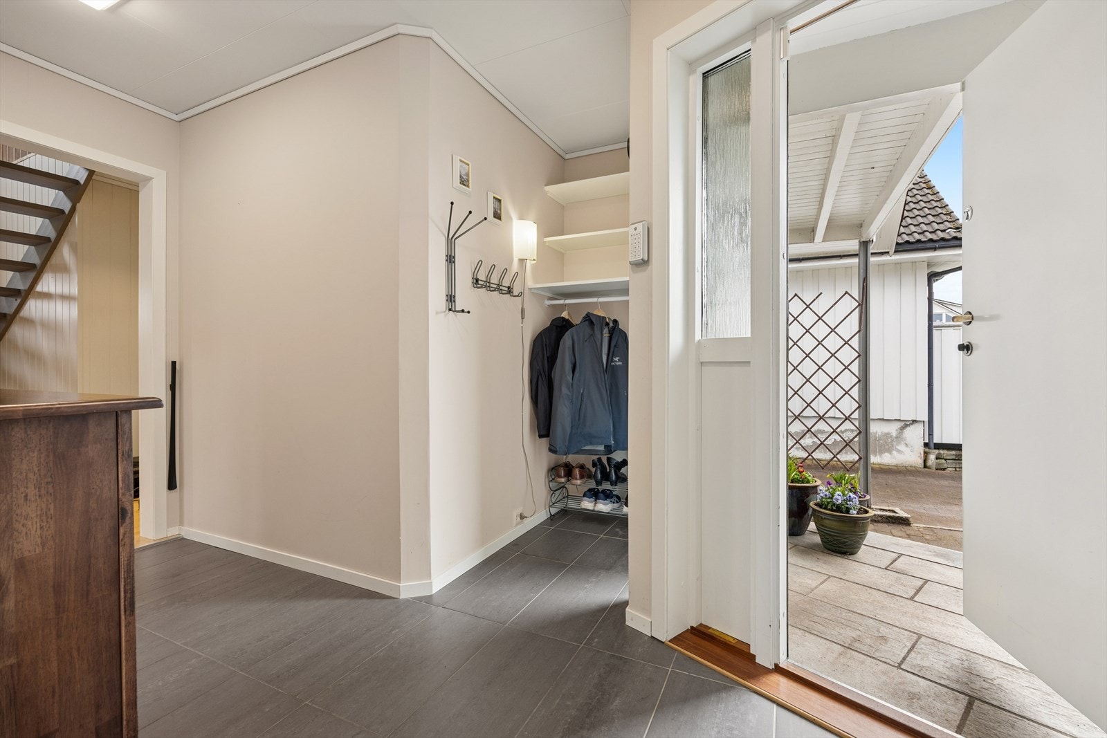 Romslig, flislagt gang med god plass til oppbevaringsløsninger. Galleribilde