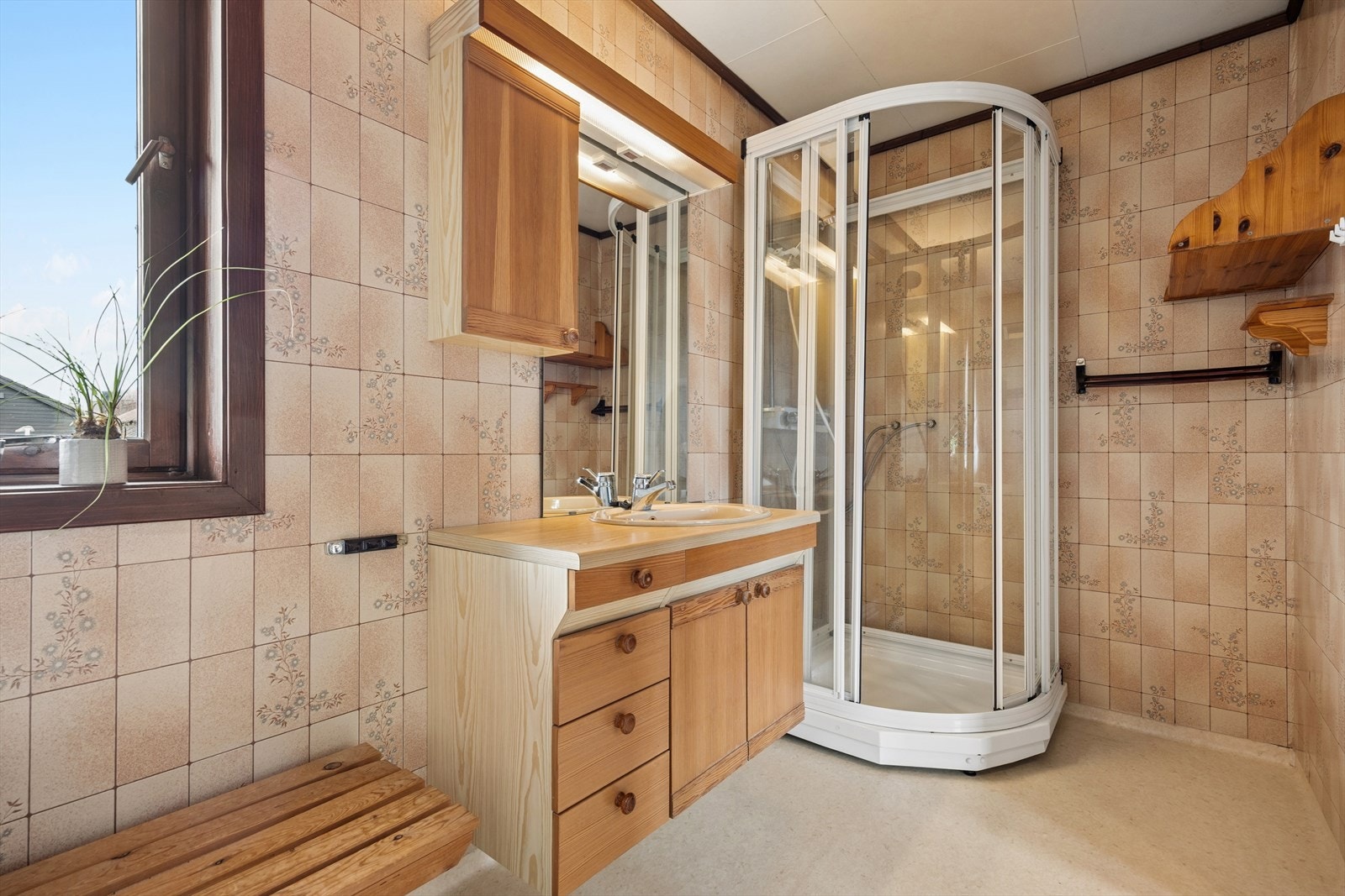 Badet i denne etasjen er innredet med servant på innredning, dusjkabinett og gulvmontert toalett. Galleribilde