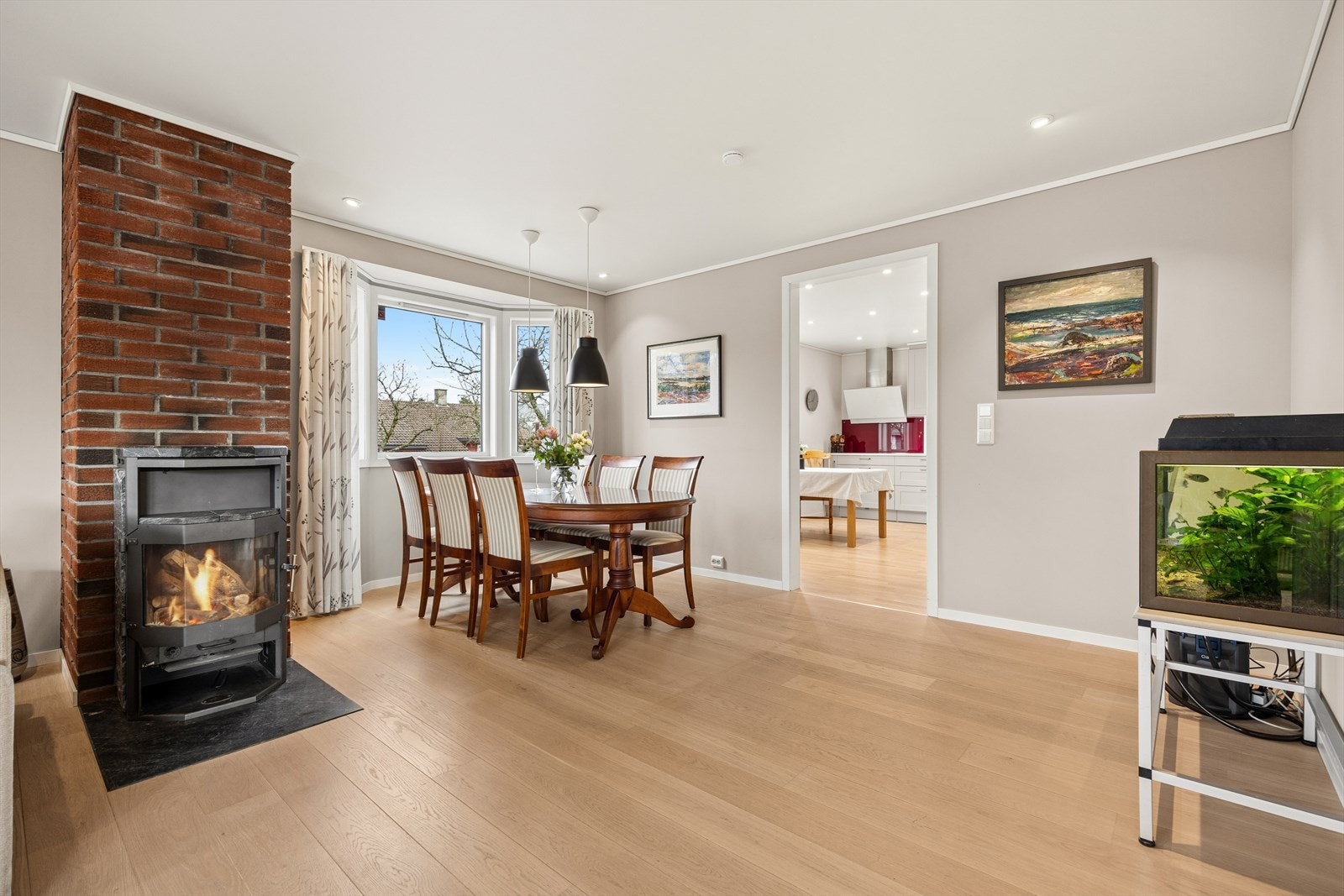 En dekorativ teglvegg og vedovn skaper en varm atmosfære. Galleribilde