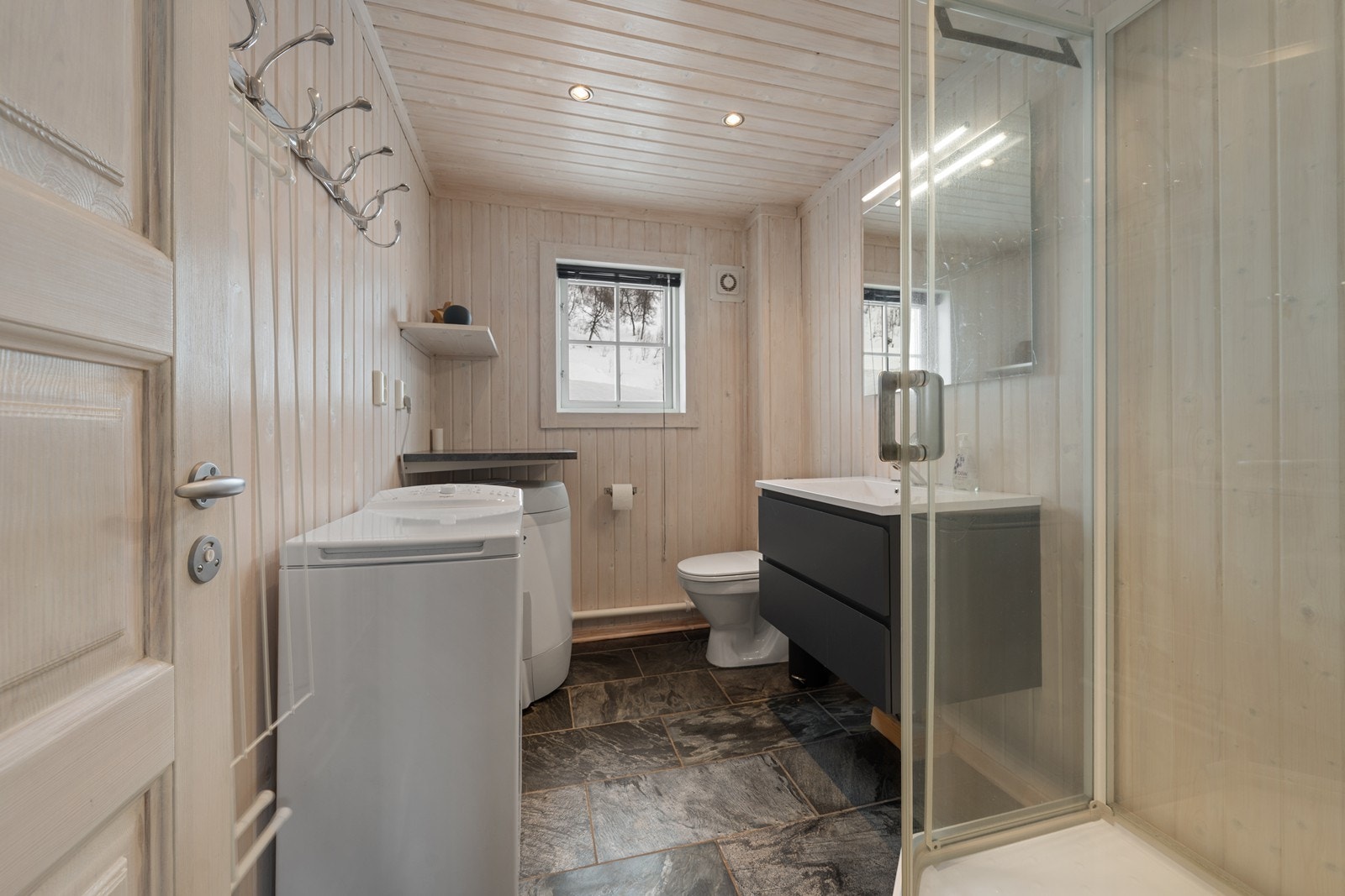 Bad/wc med fliser på gulv, varmekabler, dusjkabinett og opplegg for vaskemaskin Galleribilde