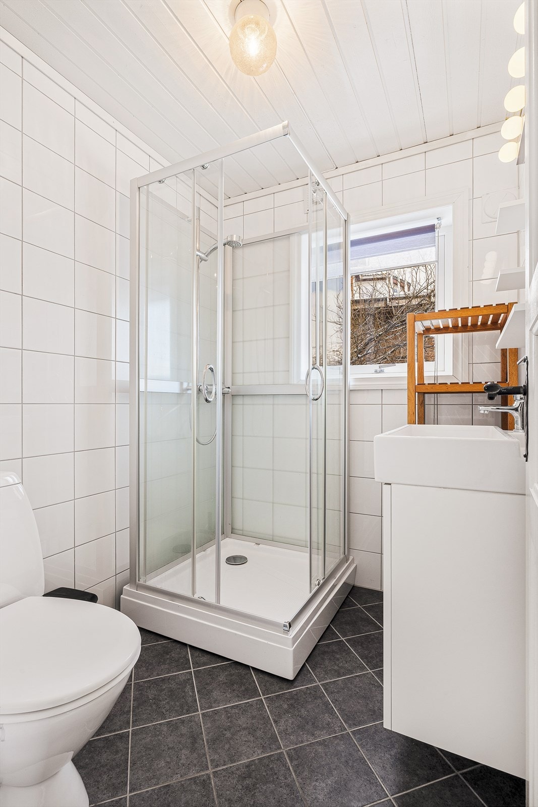 Badet inneholder bla servant, toalett, og dusjkabinett. Galleribilde