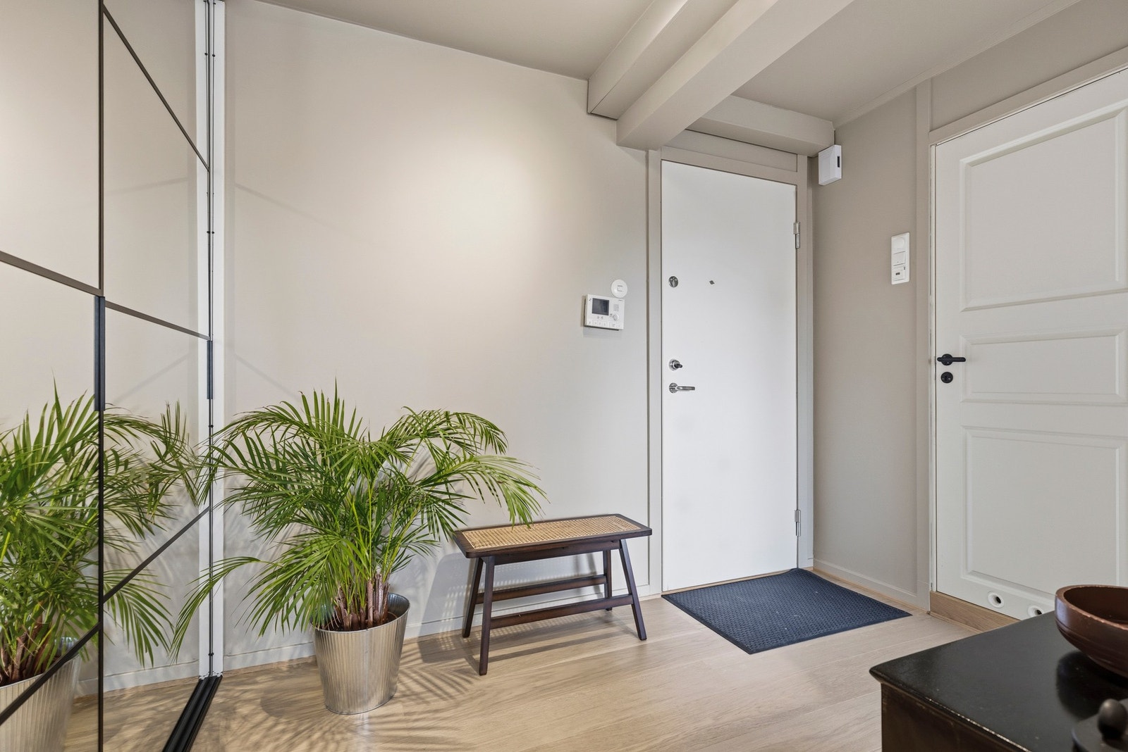 Entréen er pent innredet med parkett på gulvet og lyse vegger Galleribilde