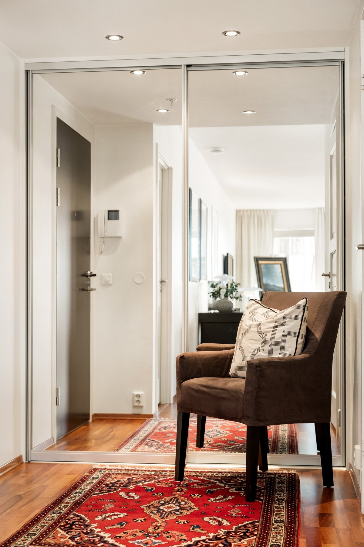 Her er det heisadkomst til leilighetens innbydende entré, med praktisk skyvedørsgarderobe. Galleribilde