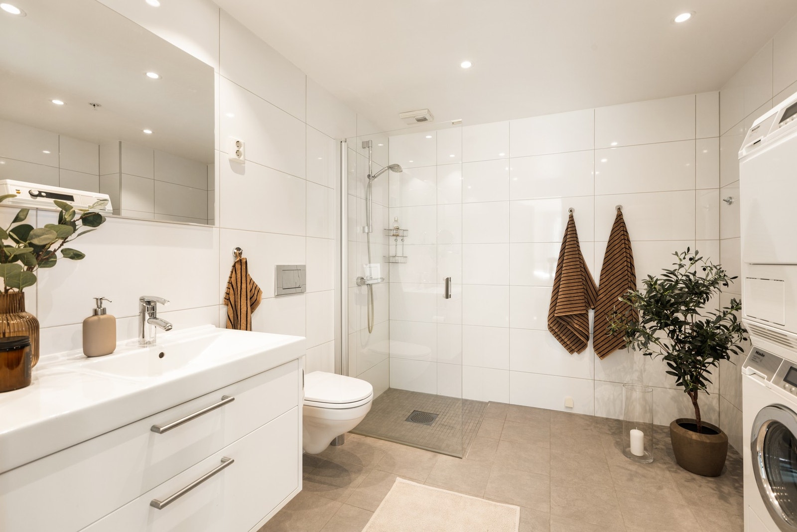 Hovedbadet ligger i tilknytning til hovedsoverommet og har en suite-løsning som gir en privat og hotell-inspirert følelse. Her er det opplegg for vaskemaskin og tørketrommel. Galleribilde