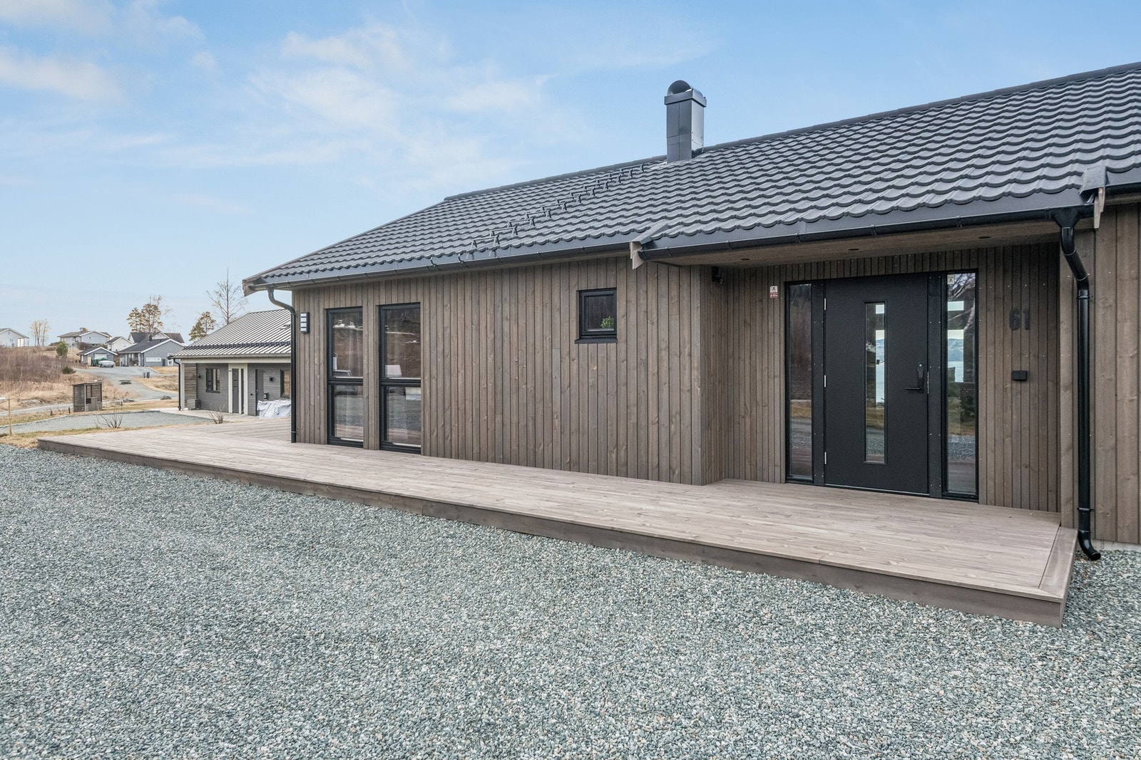 Trivelig inngangsparti med terrasse som strekker seg videre rundt hytta. Det er installert kameraovervåkning med appstyring både ved inngangspartiet og på terrassen, slik at man enkelt kan følge med på eiendommen selv når man ikke er på hytta. Galleribilde