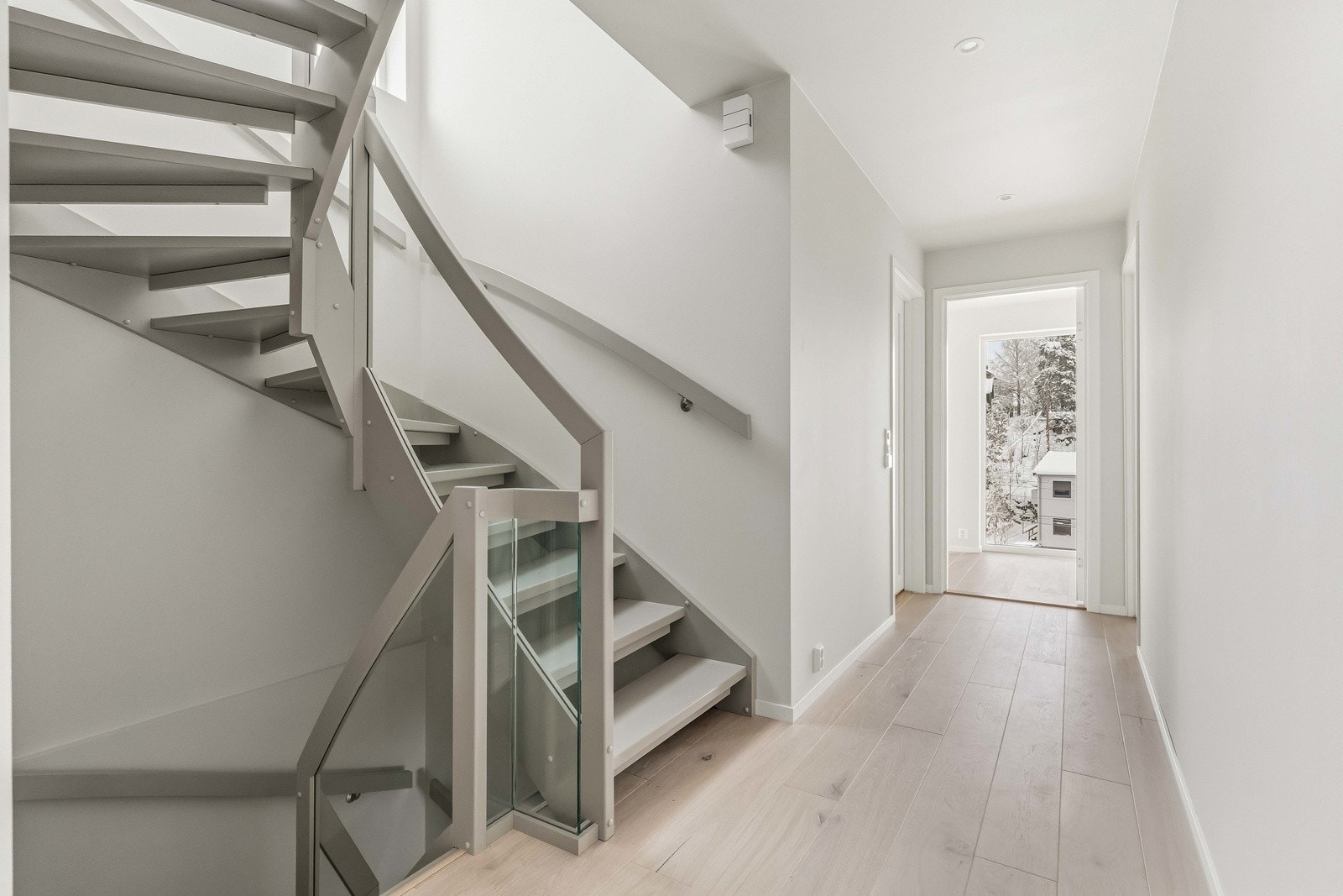 Elegant trappeløsning som knytter etasjene sammen og gir boligen et moderne og gjennomført uttrykk med glassrekkverk. Galleribilde
