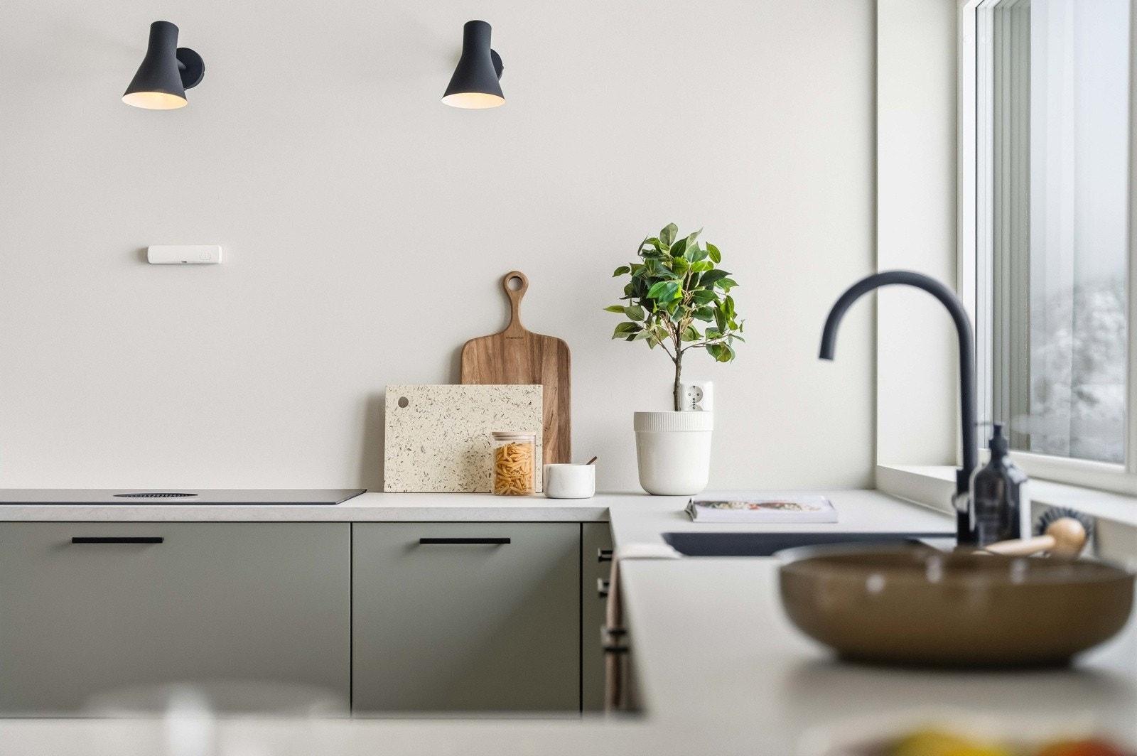 Kjøkkenet er utstyrt med stilren servant og armatur. Galleribilde