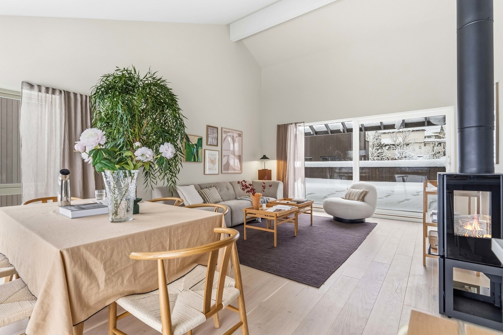 Spisestuen ligger i åpen forbindelse med stuen, hvor peisen gir rommet et naturlig samlingspunkt og bidrar til både varme og stemning. Galleribilde