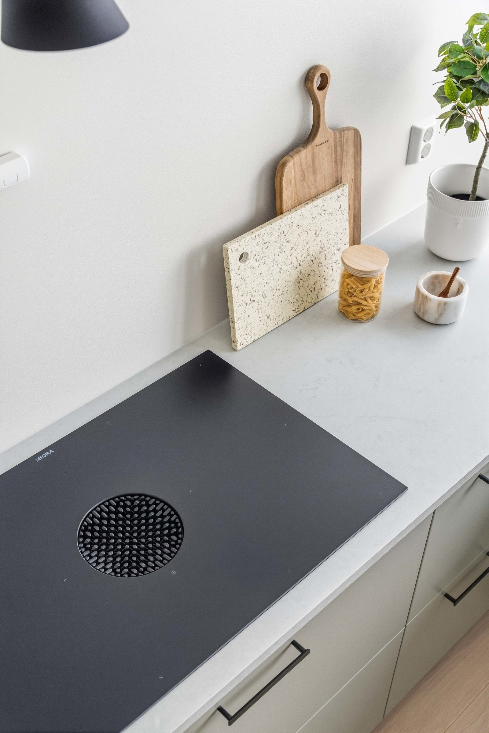 Kjøkkenet har påkostet Bora-platetopp med integrert ventilator som gir effektiv avtrekksløsning og et rent visuelt uttrykk uten tradisjonell kjøkkenvifte. Galleribilde