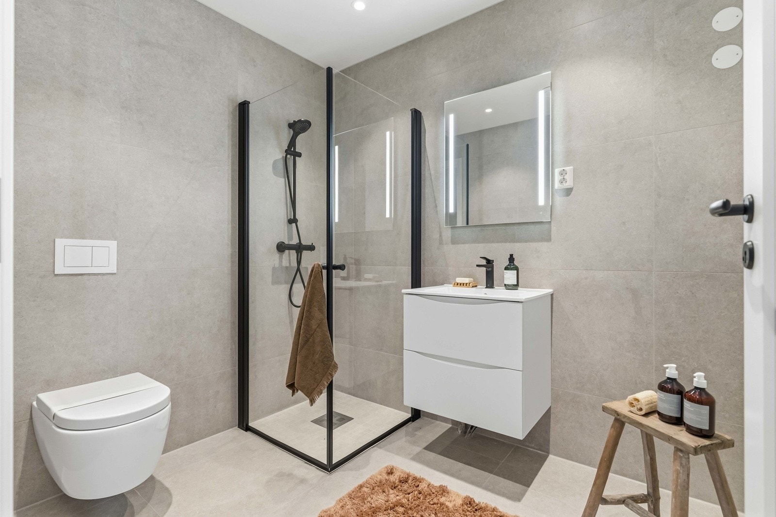 Badet er moderne utformet med flislagte overflater, varmekabler i gulv og en ryddig, funksjonell løsning. Galleribilde