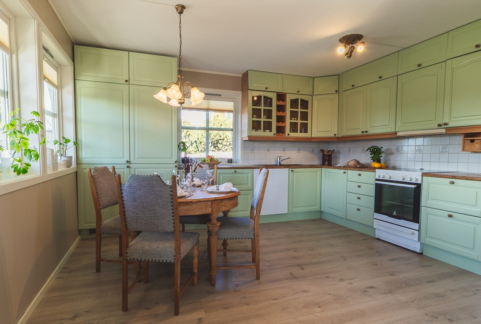 Kjøkkenet har grønnmalt innredning, god skap- og benkeplass samt plass til spisebord Galleribilde