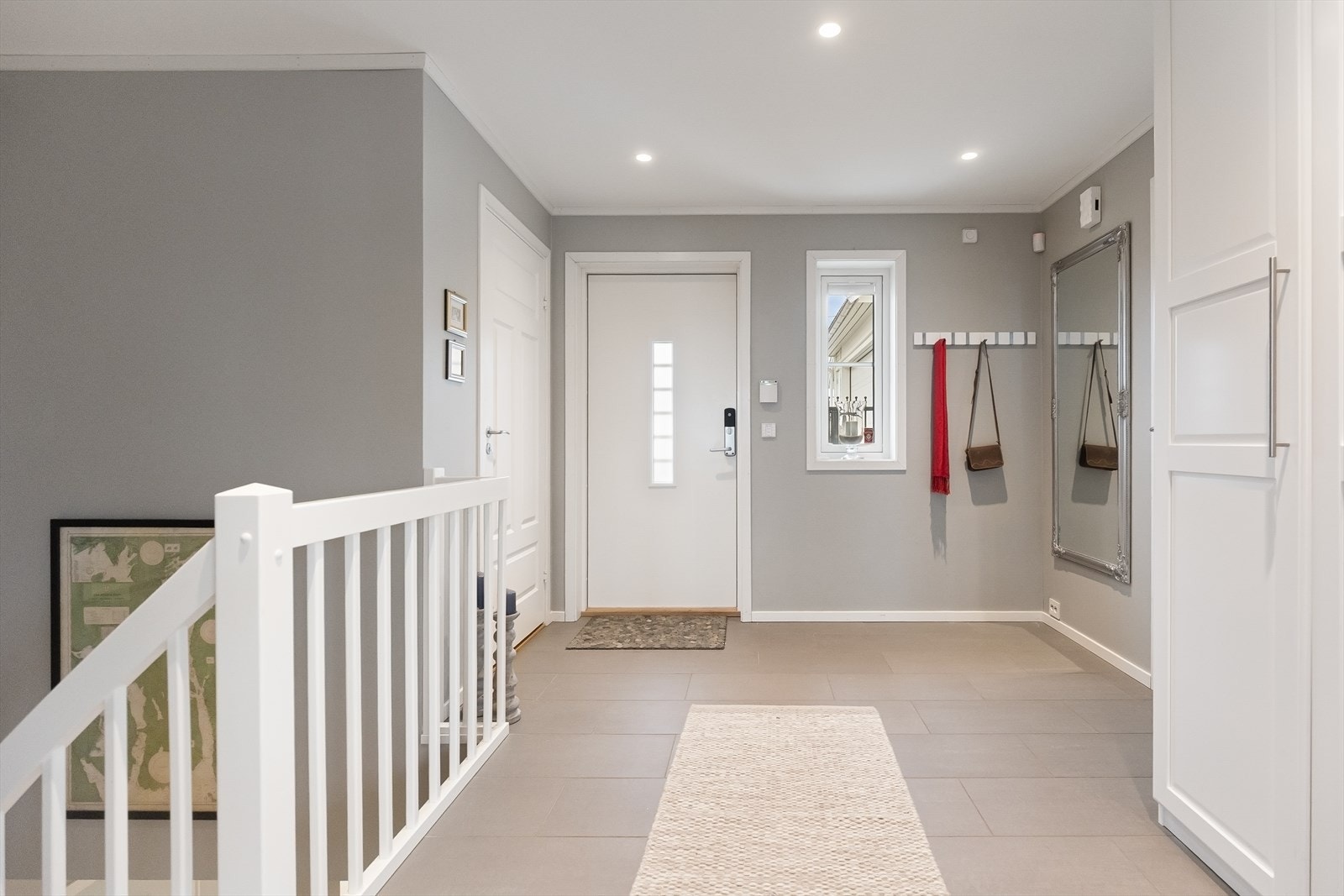 Stor og lys gang med flislagt gulv og vannbåren varme. Galleribilde