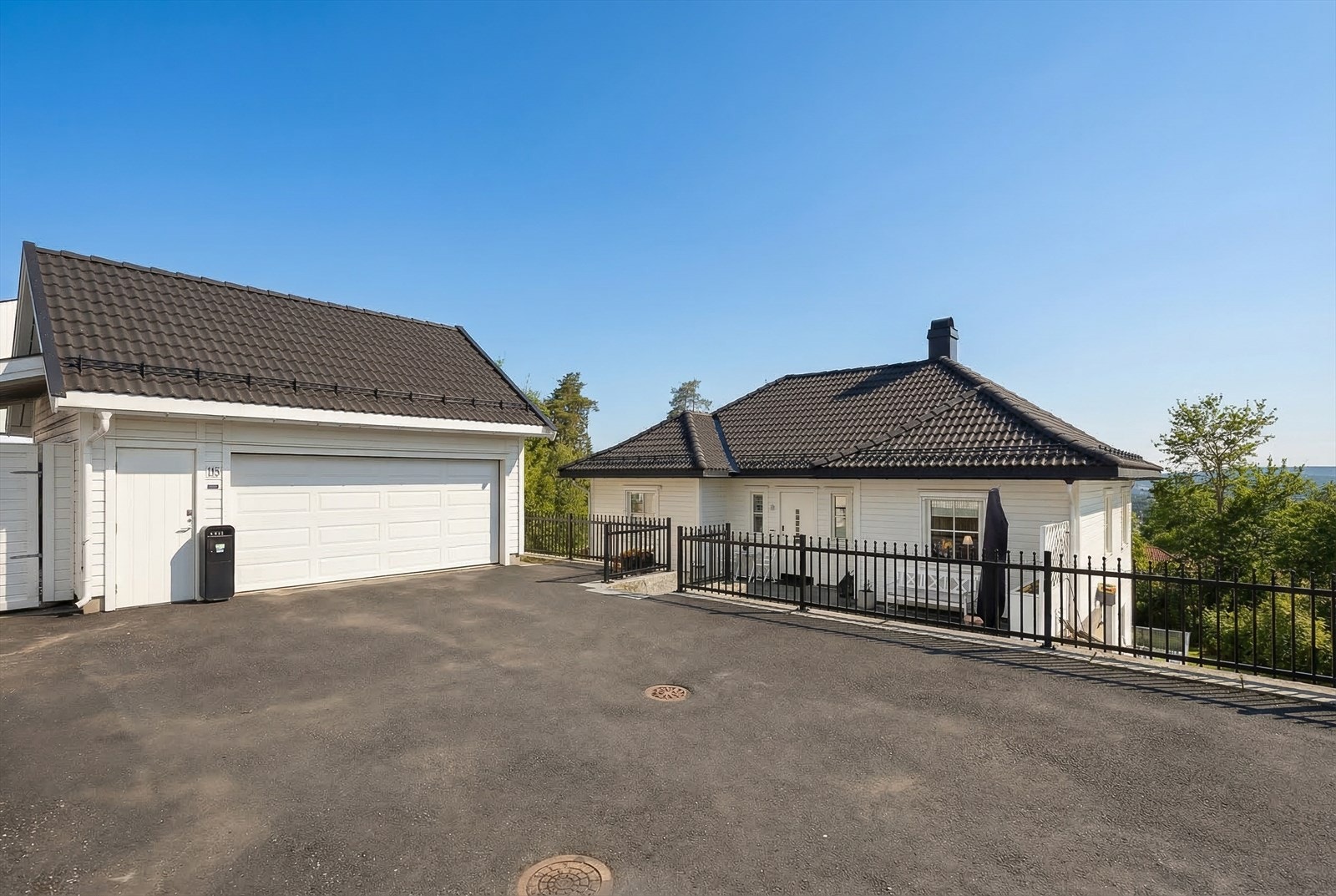 Stor asfaltert gårdsplass med gode parkeringsmuligher og frittstående dobbelgarasje, fullisolert med epoxybelegg på gulvet samt 2 elbil-ladere. (Vinterbilde redigert til sommer, avvik kan forekomme) Galleribilde