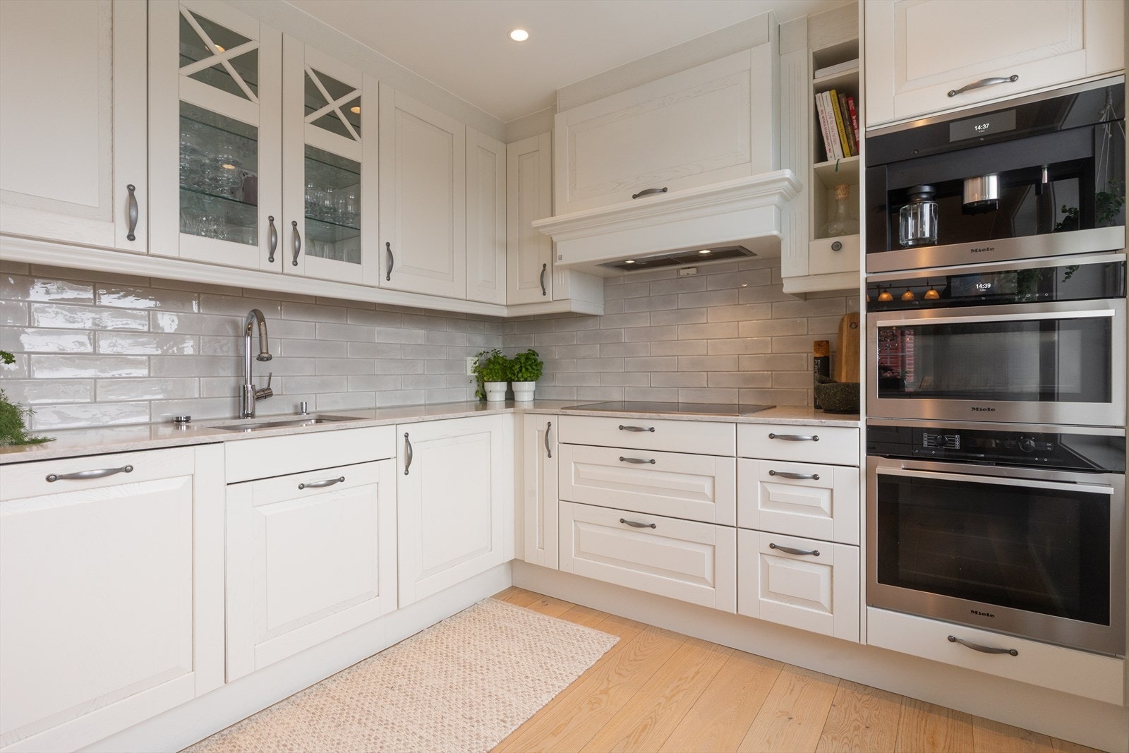 Flott kjøkken med profilerte fronter i hvit utførelse. Galleribilde