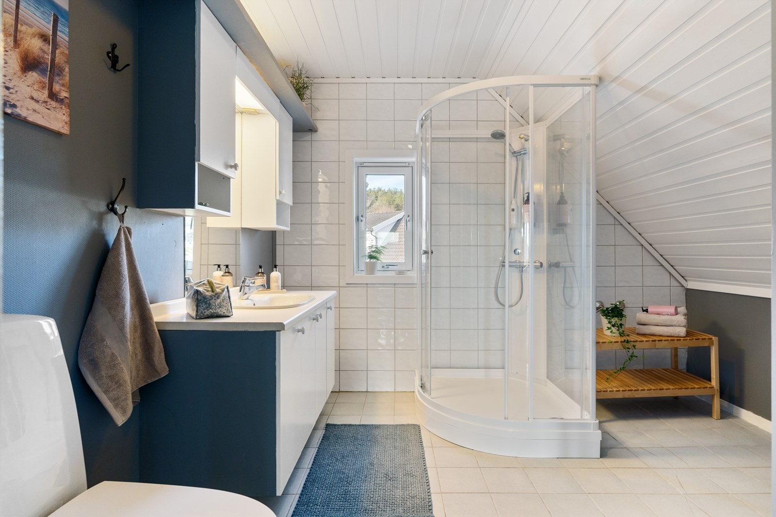 Badet har varme i gulv, og er innredet med dusjkabinett, servant og baderomsinnredning. Galleribilde