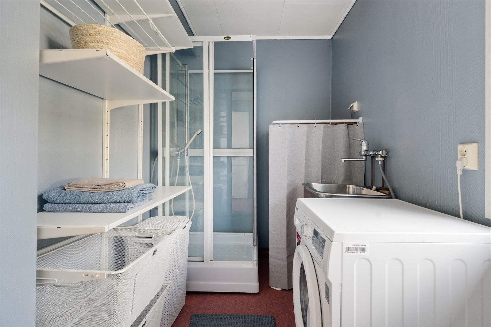 Vaskerommet er praktisk innredet med hyller, utslagsvask og opplegg for vaskemaskin. Galleribilde