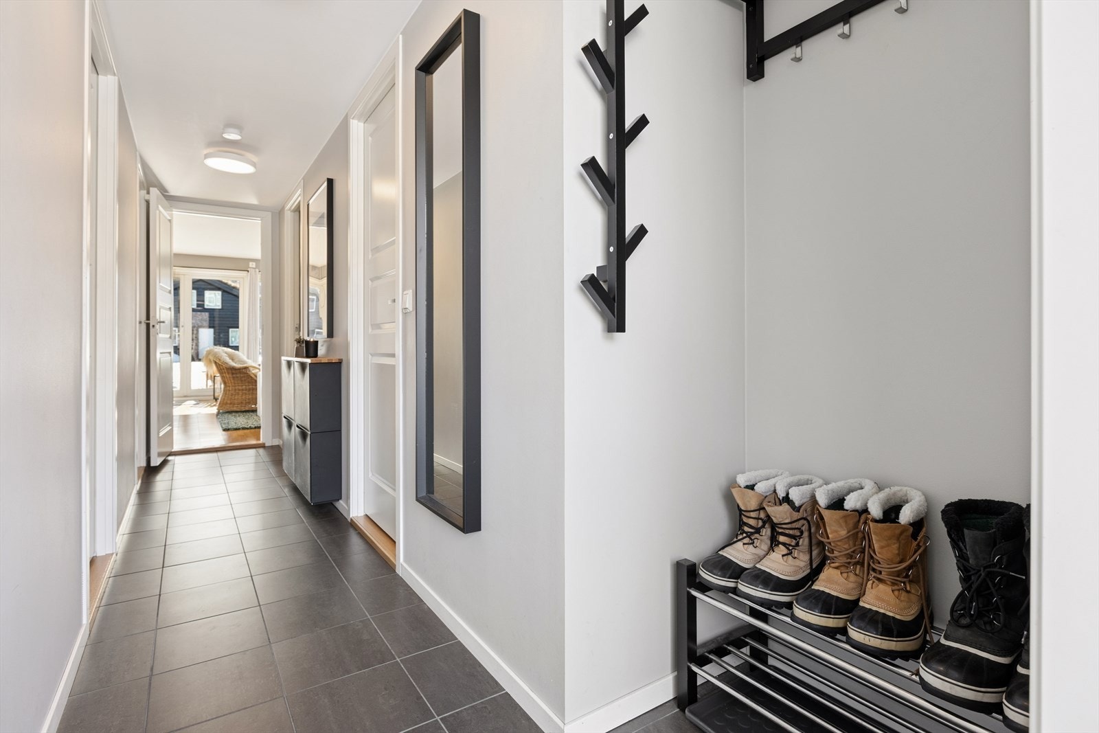 Lys og trivelig entrè med plass til å henge fra seg yttertøy og sette fra seg sko. Galleribilde