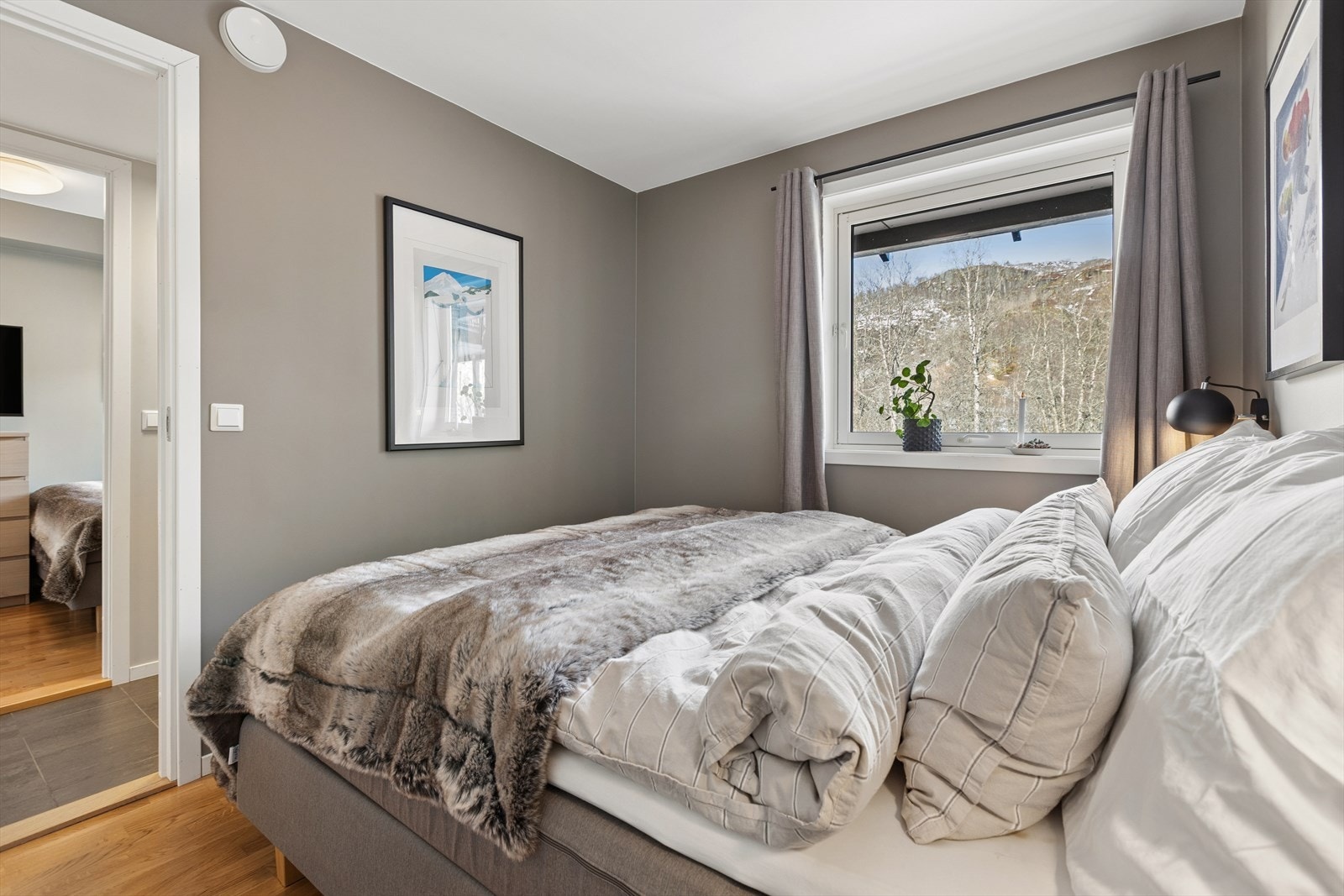 Parkettgulv og malte vegger gir et rent og vedlikeholdsvennlig soverom. Galleribilde