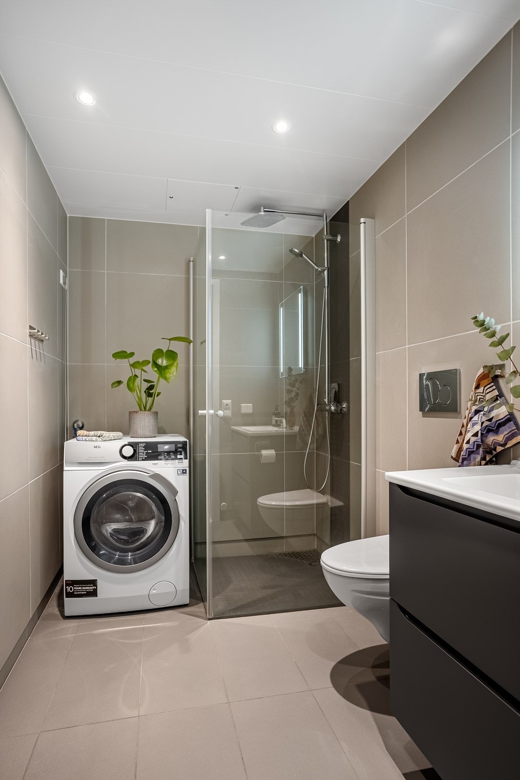 Badet har elektriske varmekabler i gulvet for ekstra komfort, samt praktisk opplegg for vaskemaskin. Galleribilde