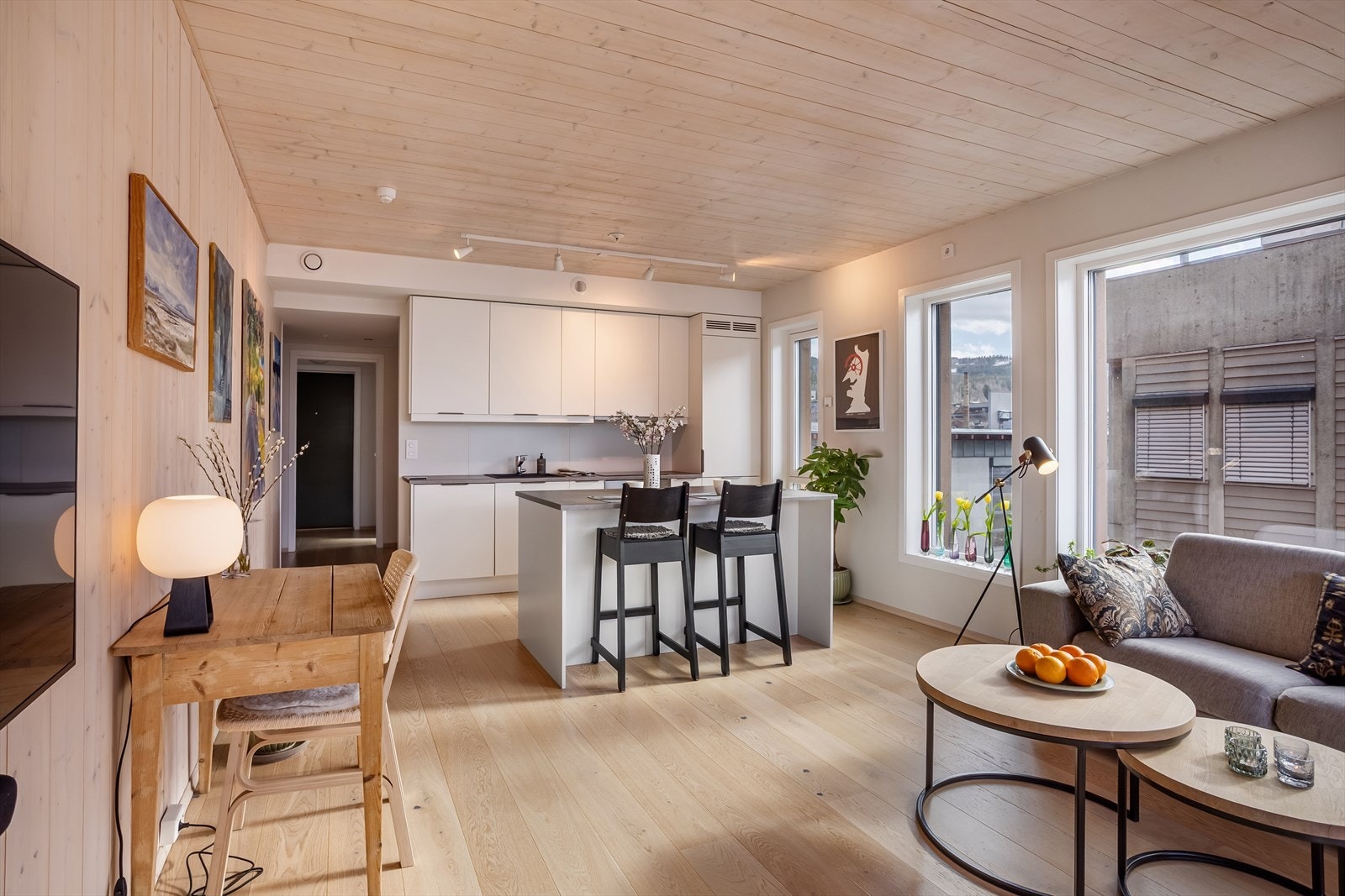 Det sosiale allrommet kombinerer stue og kjøkken, med en praktisk kjøkkenøy som et naturlig samlingspunkt. Galleribilde