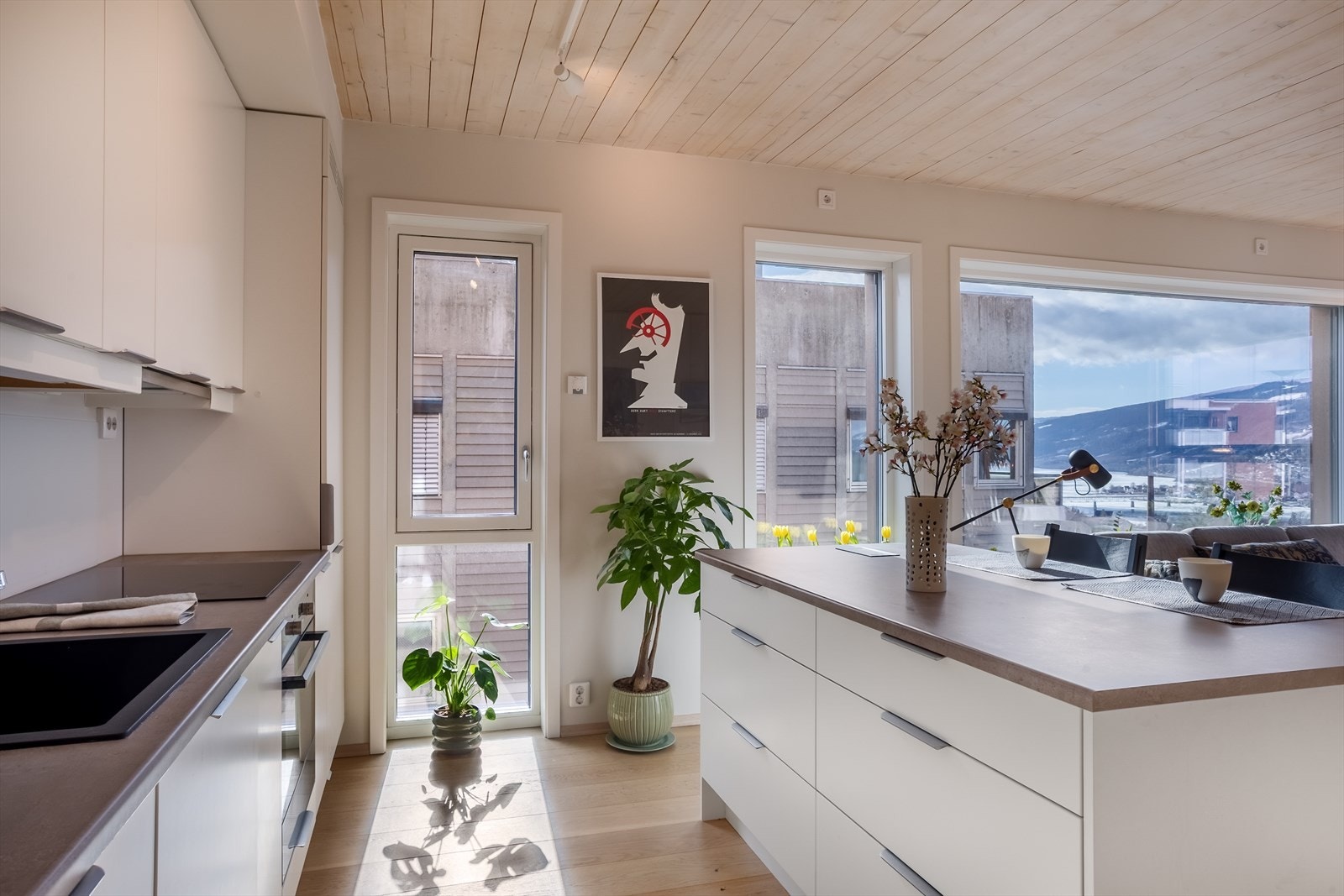 Stilren kjøkkeninnredning fra Strai med glatte fronter, laminat benkeplate og nedfelt komposittvask. Galleribilde