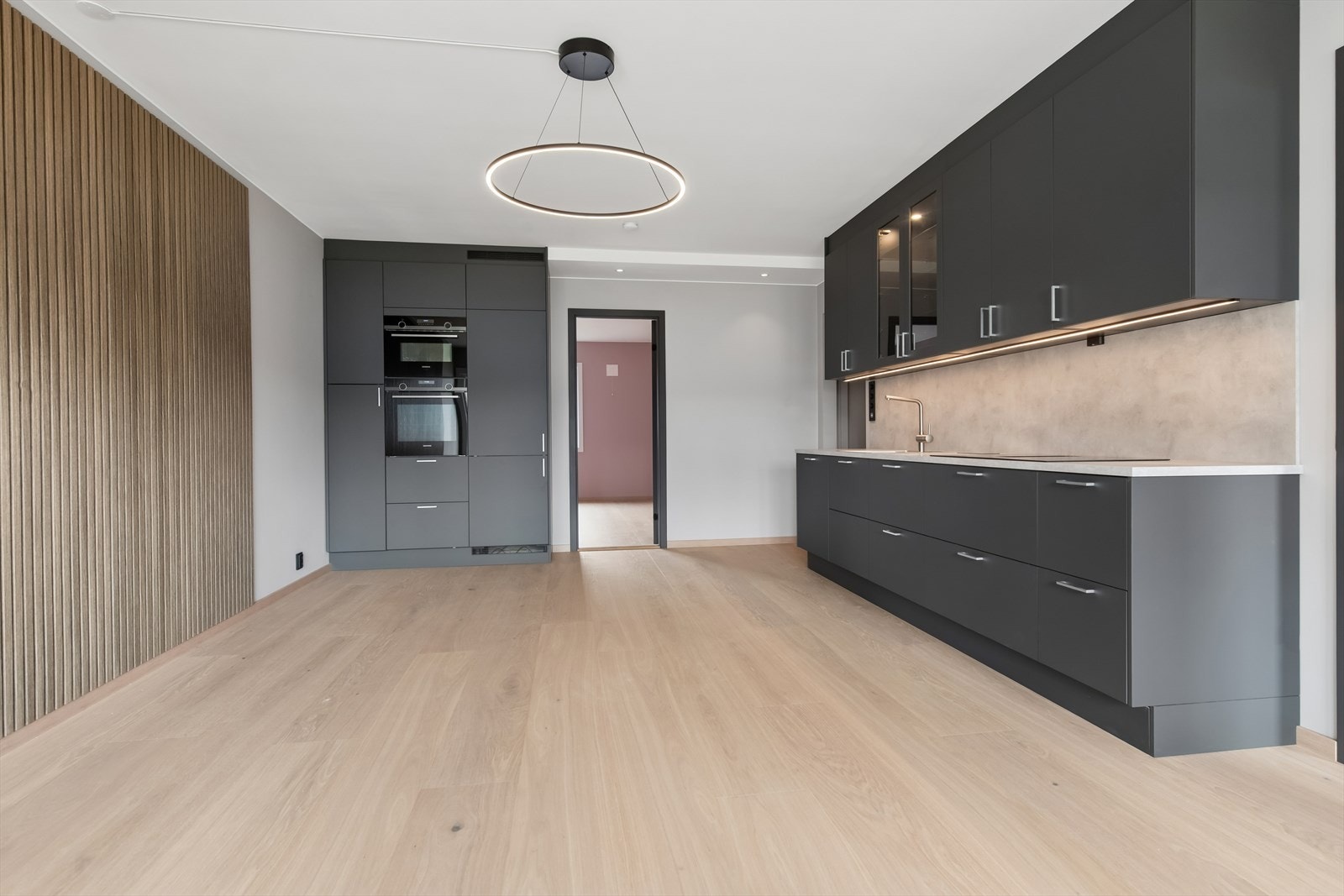 Kjøkkenet fremstår moderne, stilrent og gjennomført med en mørk og elegant innredning fra 2026 som strekker seg helt til taket. Hvitevarer inkluderer platetopp, stekeovn, mikrobølgeovn, oppvaskmaskin og kjøle/fryseskap. Galleribilde