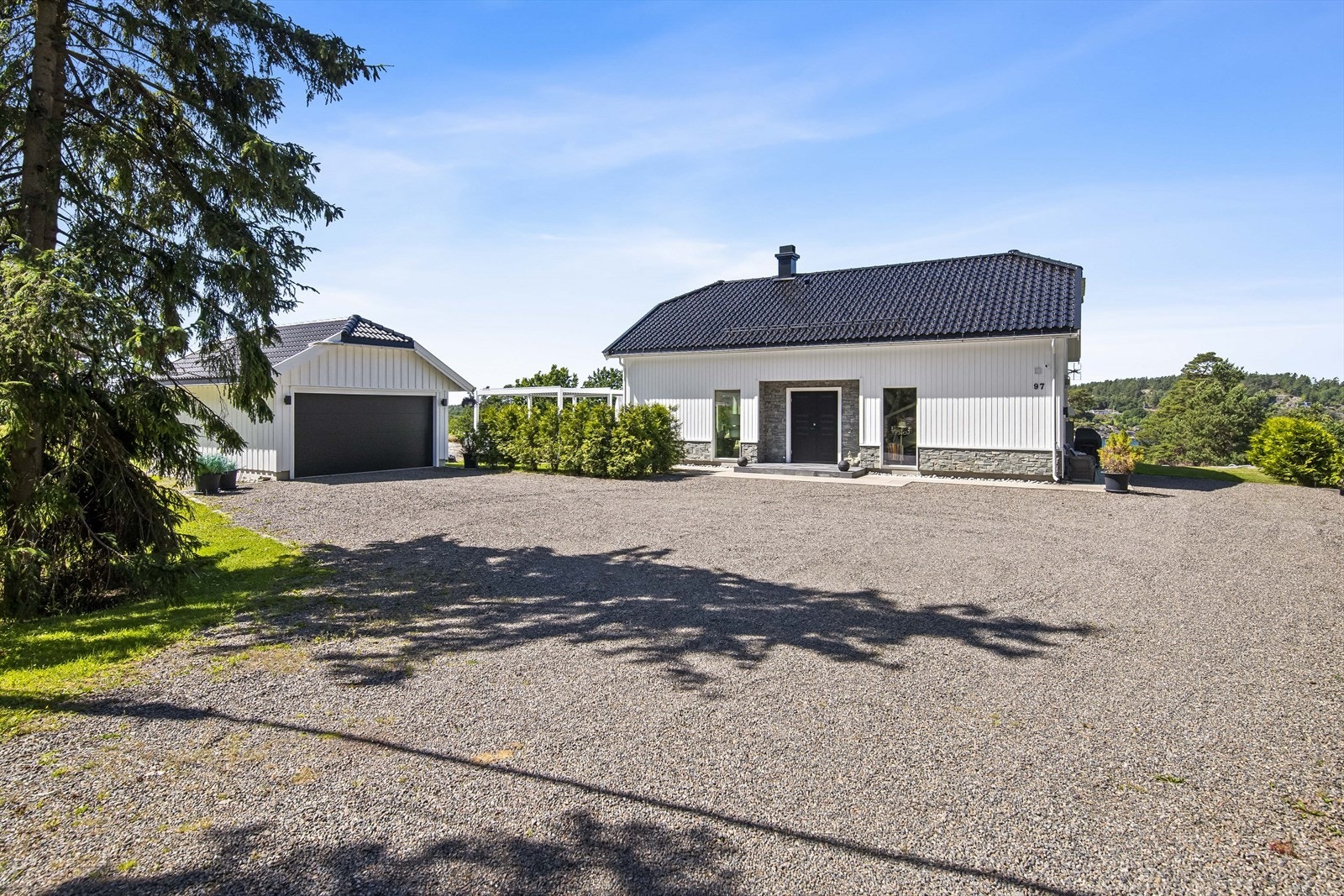 Romslig og gruset gårdsrom i front med gode parkeringsmuligheter og bilvei helt frem. Galleribilde