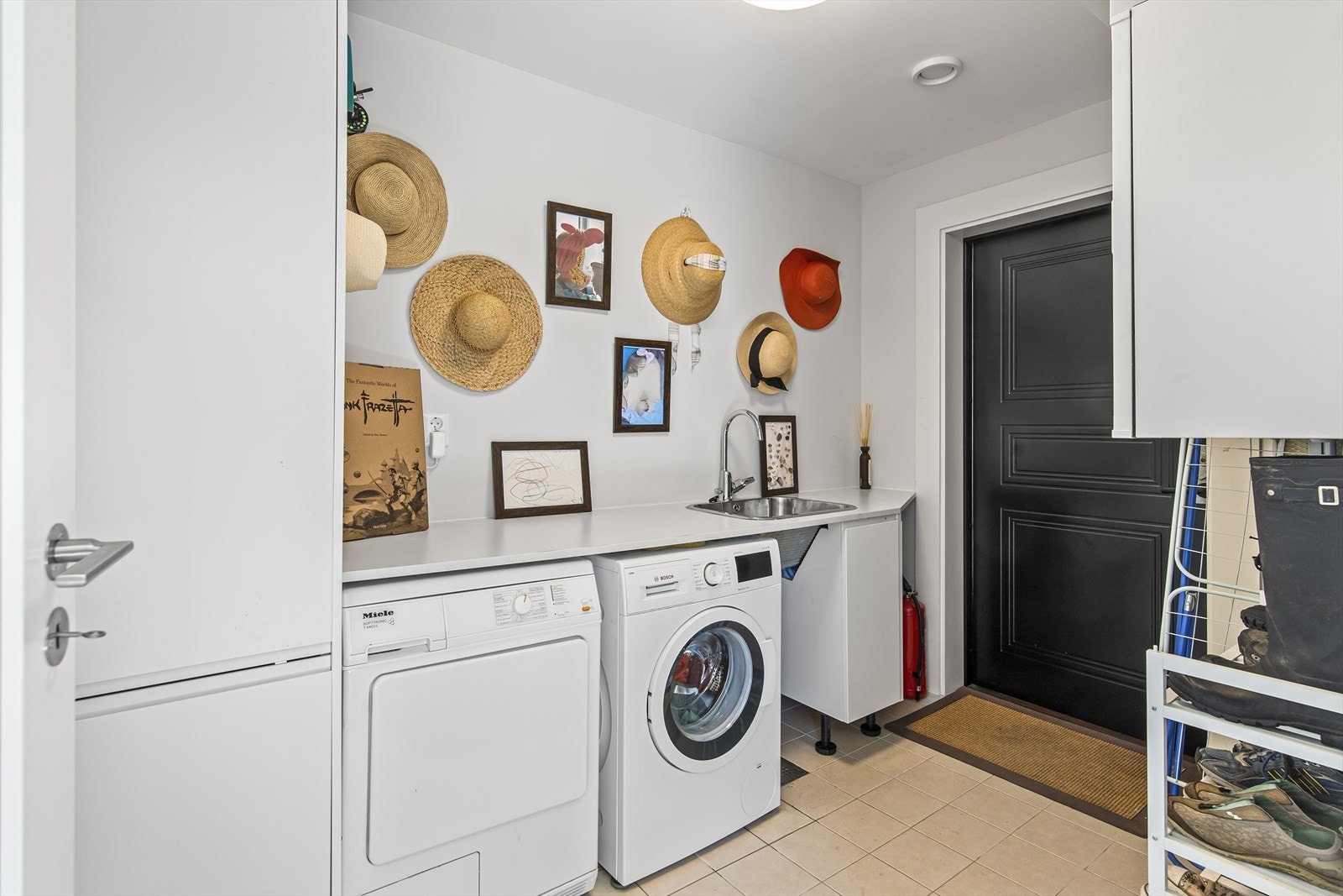 Fra hallen går man inn i husets vaskerom. Rommet er romslig er innredet med benk med utslagsvask og høyskap. Det opplegg for vaskemaskin og strømuttak for tørketrommel. Rommet har egen ytterdør. Galleribilde