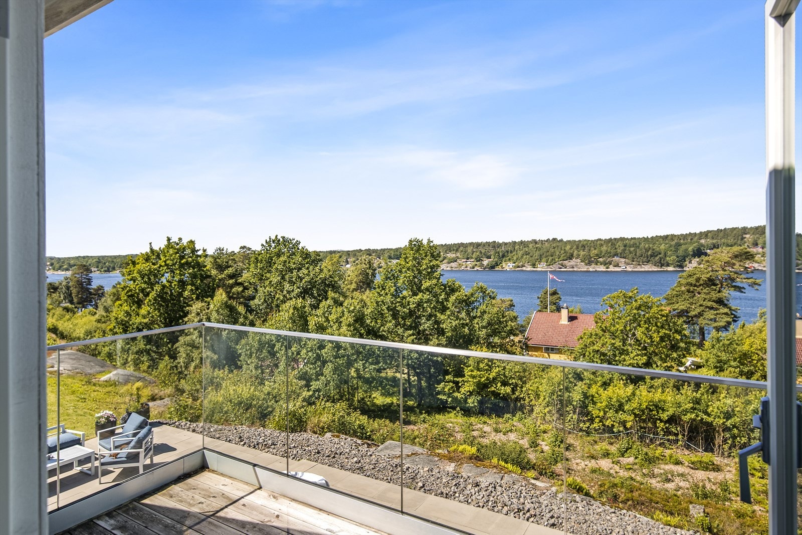 Vestvendt og solrik balkong med innglasset balkong som ikke skjermer for utsikten. Galleribilde